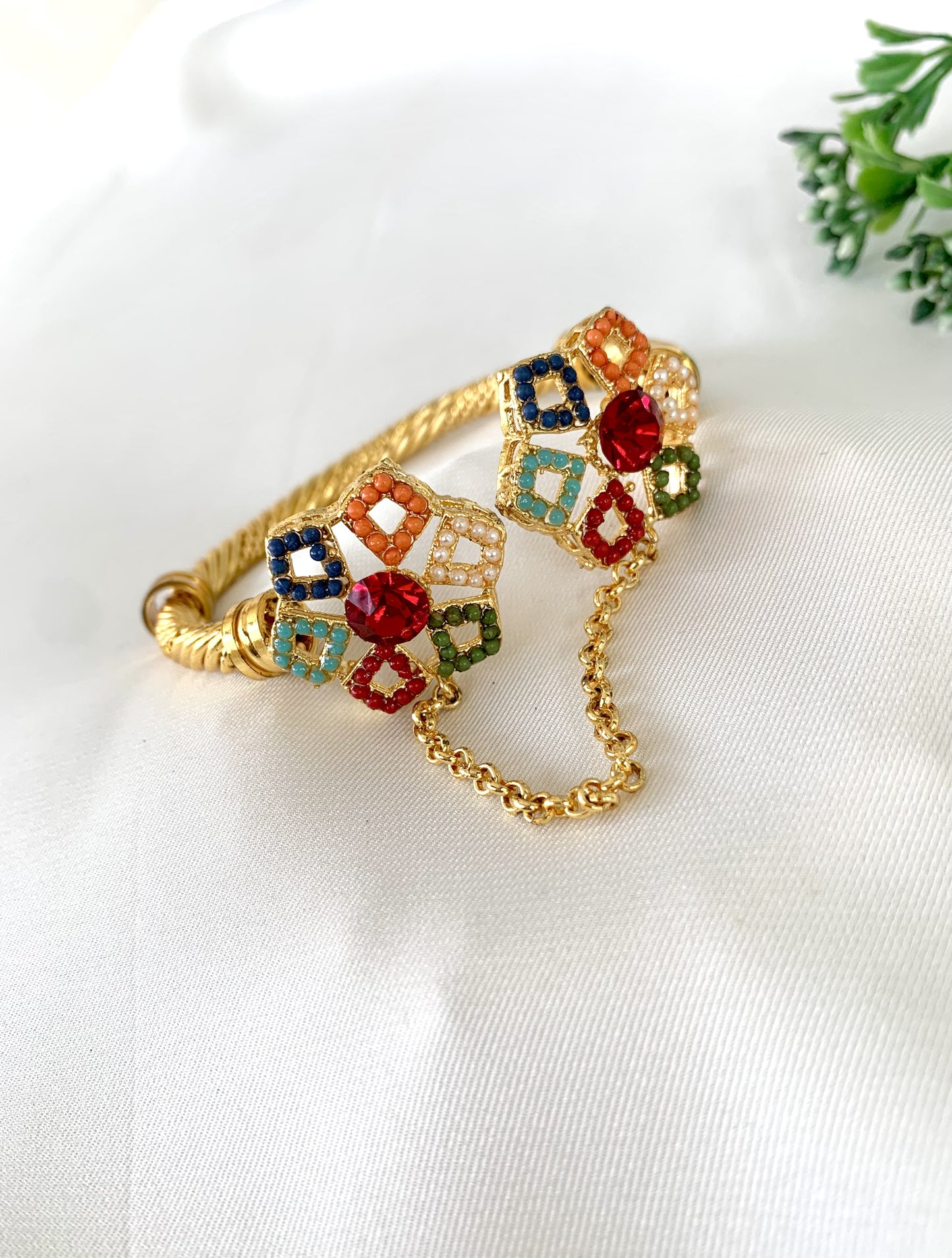 Festive floral bangle with gemstone clusters and gold chain link