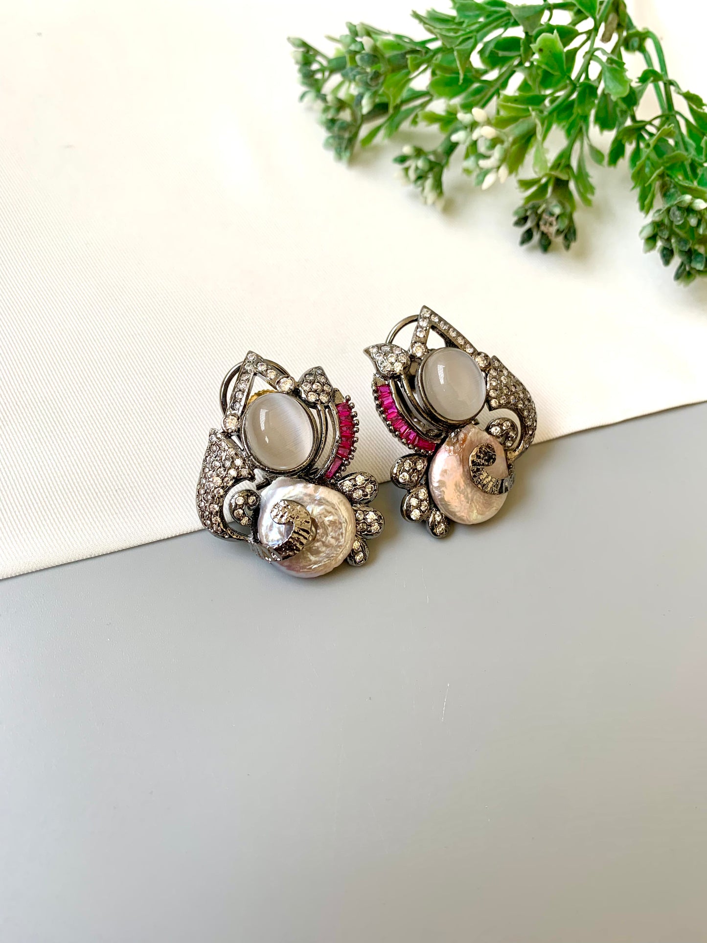 Handcrafted oxidized rhodium studs with real baroque pearls, rubies, and American diamonds by Zamal Jewels.