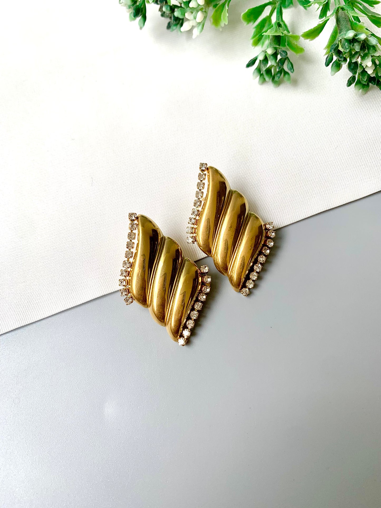 Gold-plated stainless steel studs with zircon border accents, named Solna, displayed flat lay on neutral background