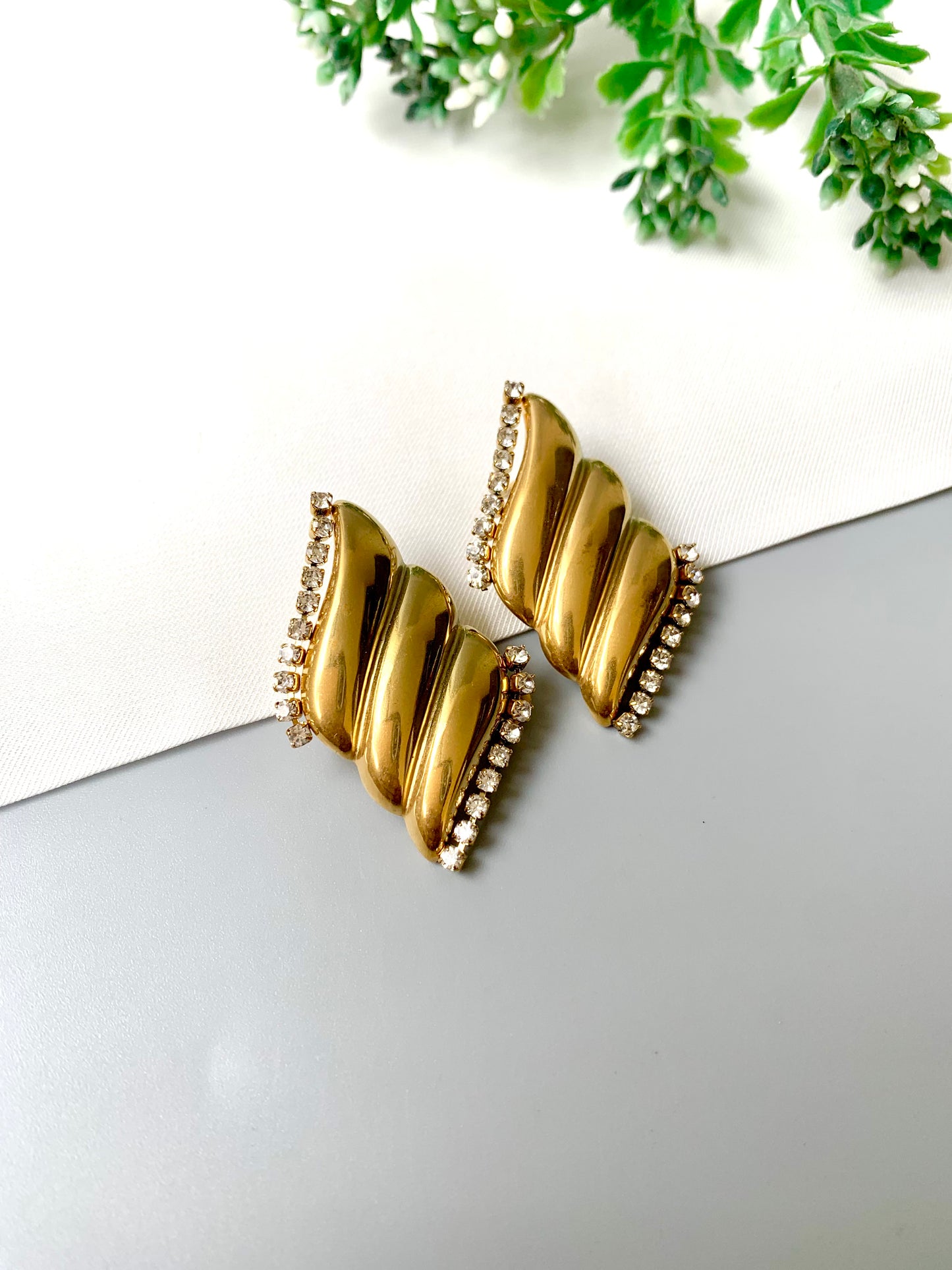 Gold-plated stainless steel studs with zircon border accents, named Solna, displayed flat lay on neutral background