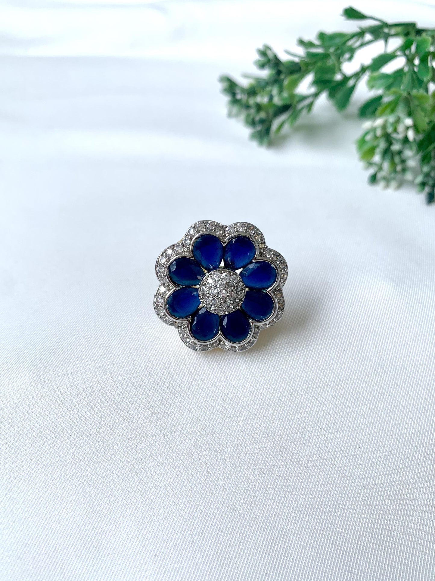 Close-up of hand-crafted floral ring with deep blue sapphire petals and American Diamonds, from Zamal Jewels
