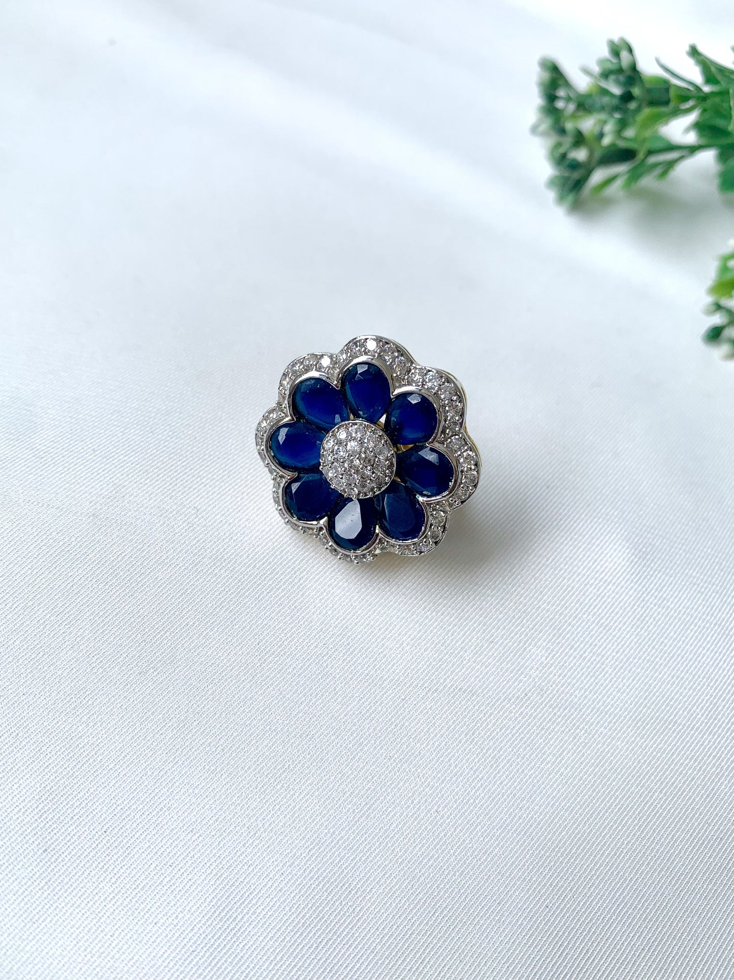Close-up of hand-crafted floral ring with deep blue sapphire petals and American Diamonds, from Zamal Jewels