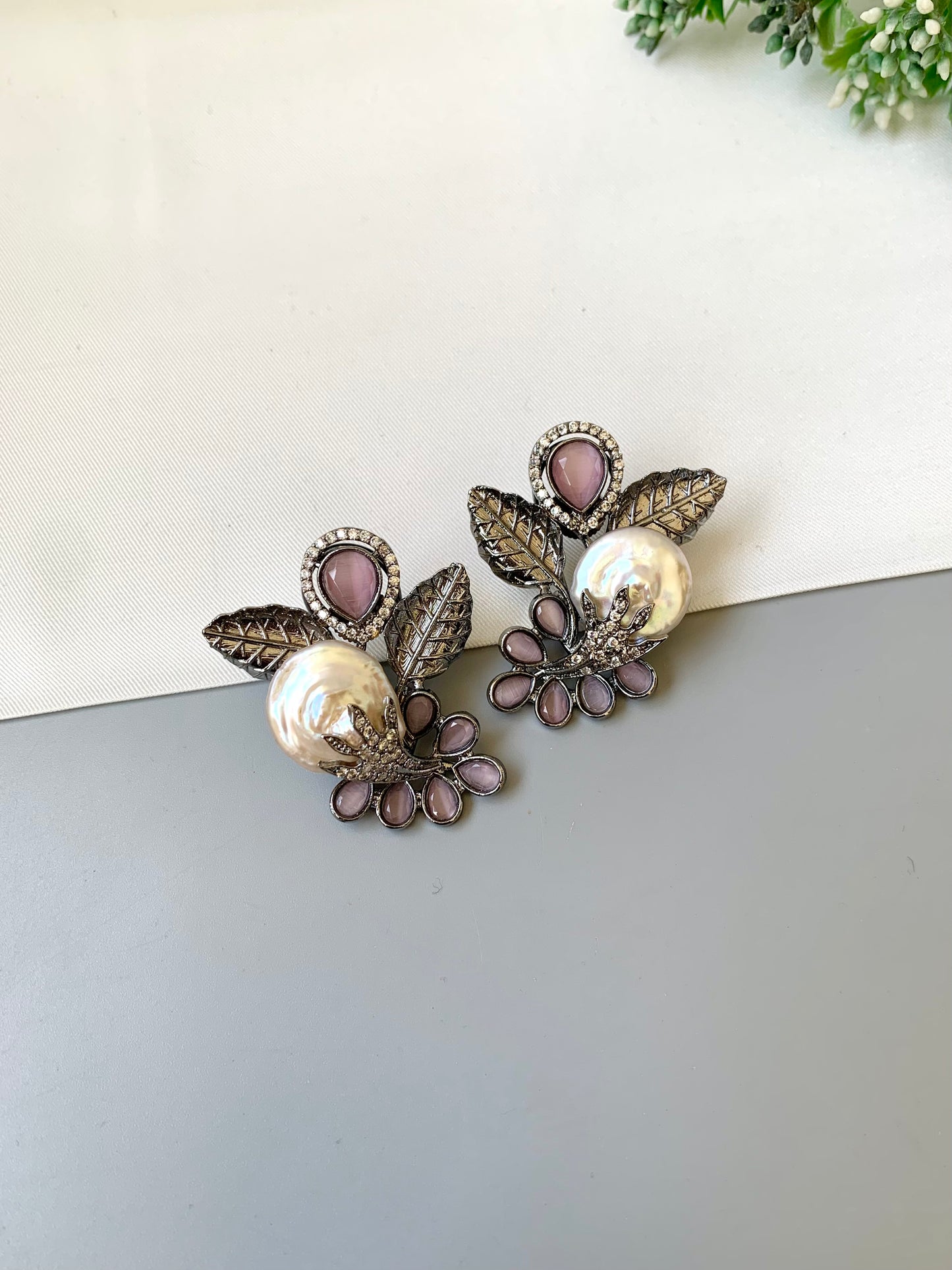 Dennis pink baroque pearl studs in rhodium oxidized finish with onyx and american diamonds