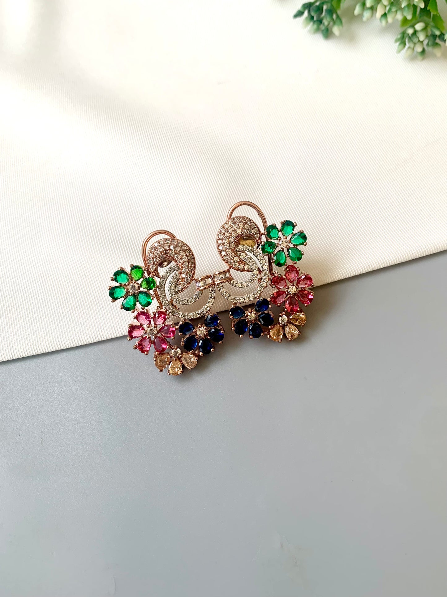 Hand crafted Dora studs in 22kt rose gold plating featuring American Diamonds and semi-precious Ruby, Emerald, Sapphire and Champagne stones