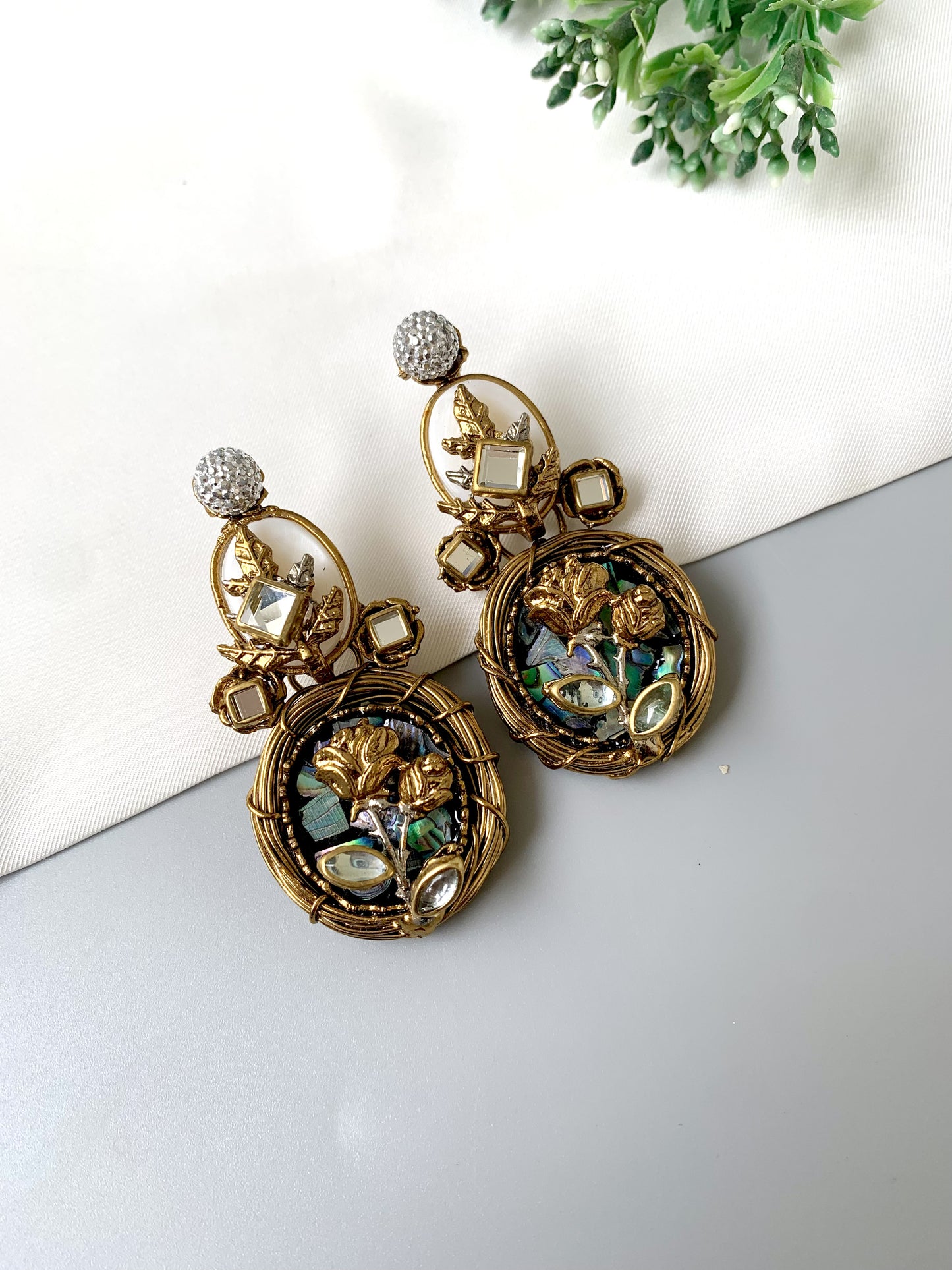 Side angle of Elara Bloom earrings in gold showing American Diamond tops and floral lower frame.