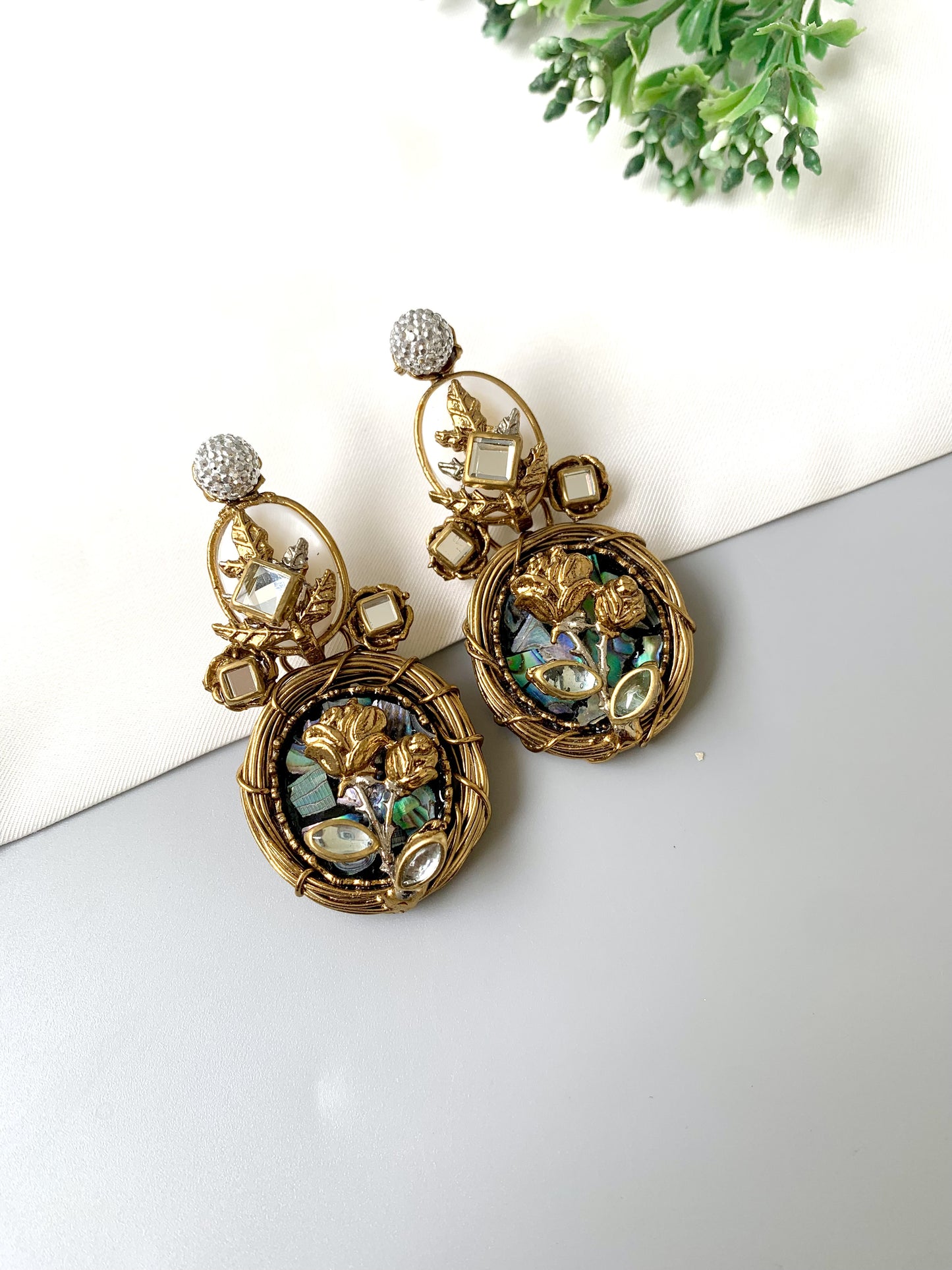 Top angle view of gold plated Elara Bloom earrings with natural moonstones, Kundan and real mother of pearl.