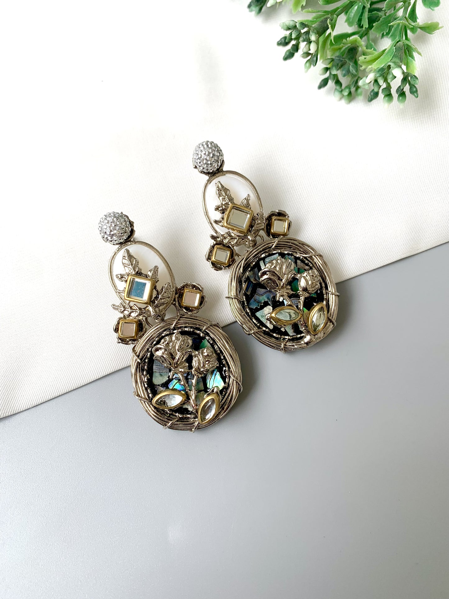 Side-angle image of Elara Bloom earrings highlighting moonstone accents and artistic floral design.