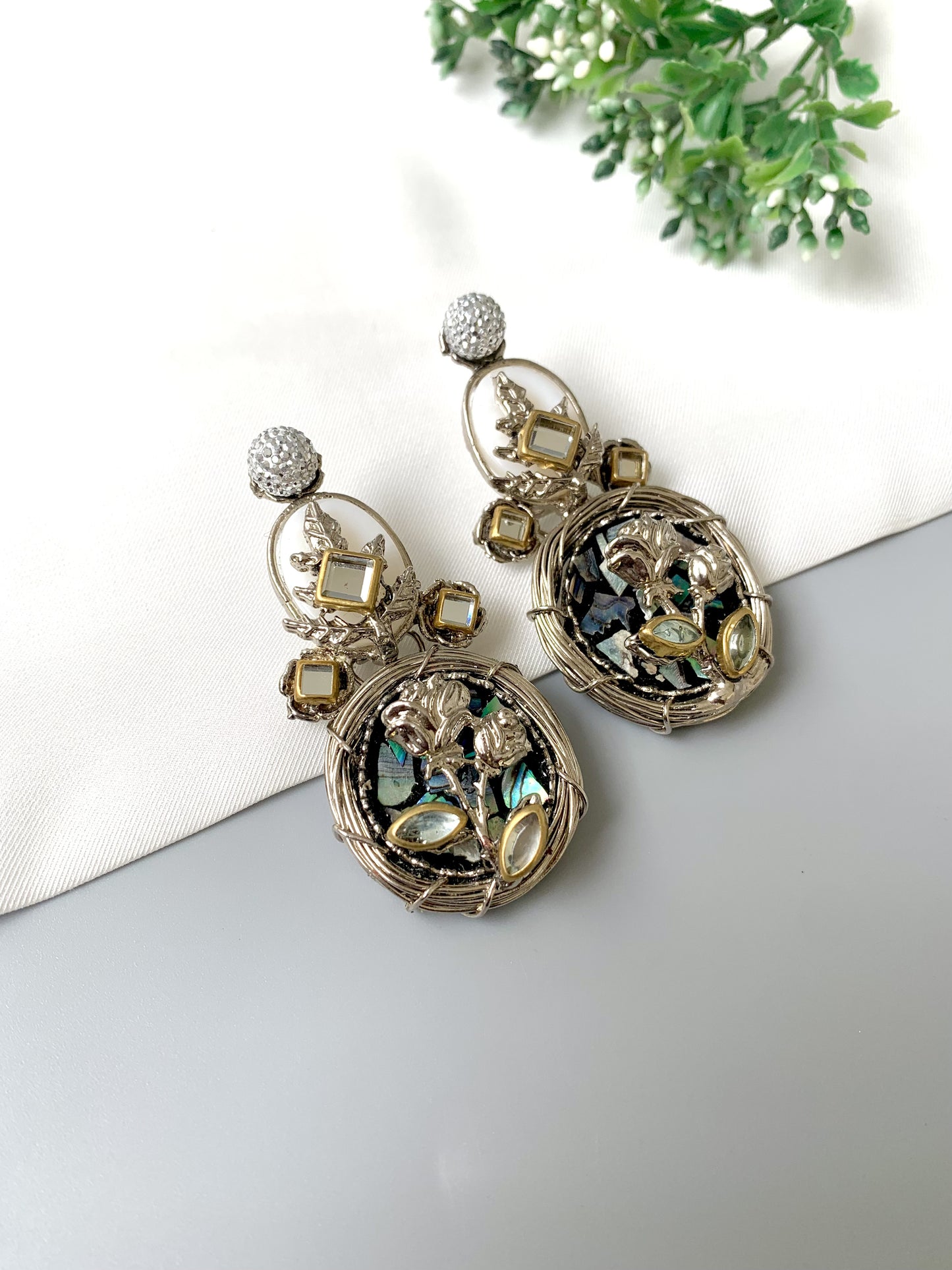 Top-angle view of Elara Bloom statement earrings in Rhodium plating with natural stones.