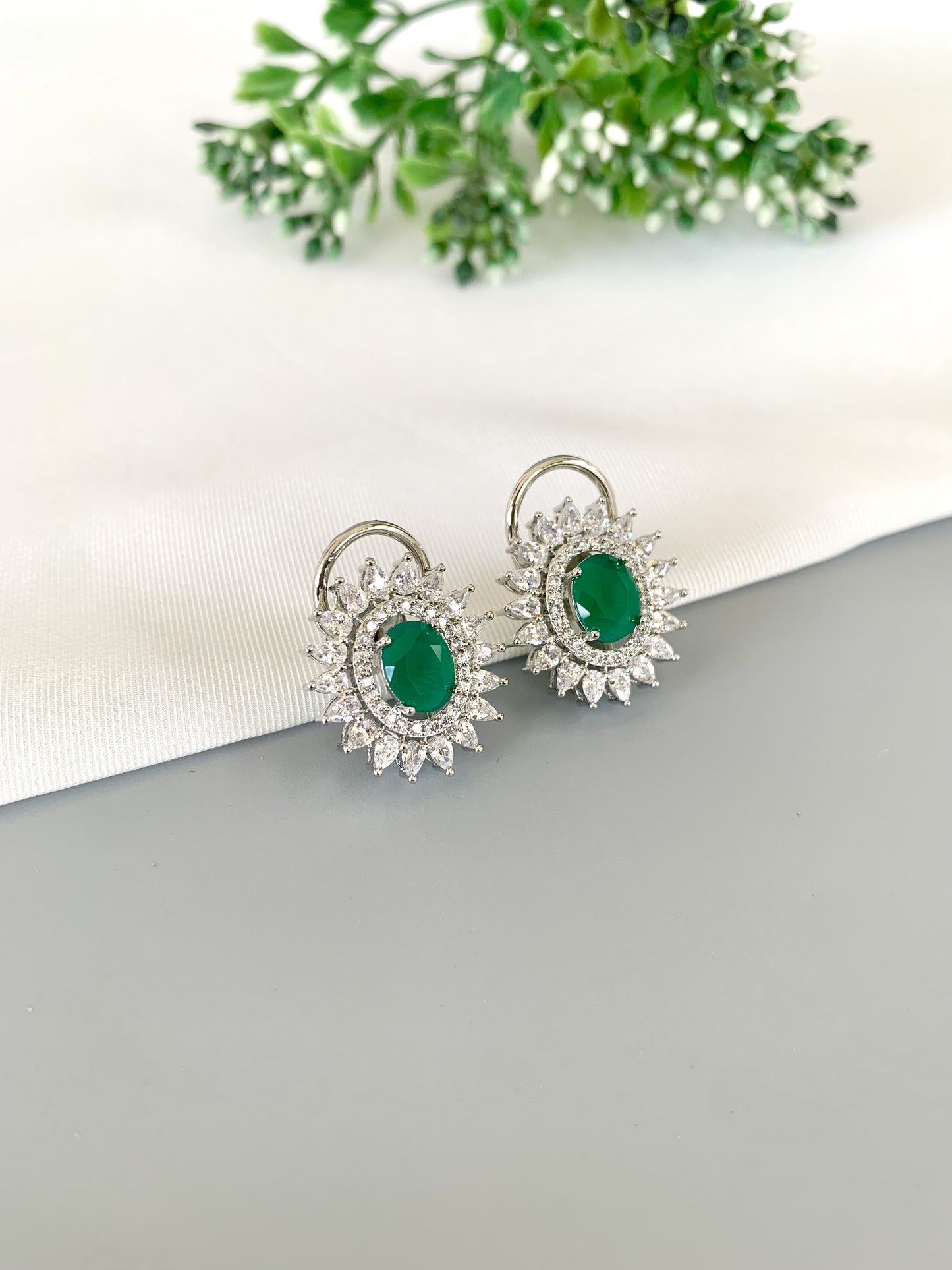 Close-up showing vibrant green Emerald center with icy diamond surround