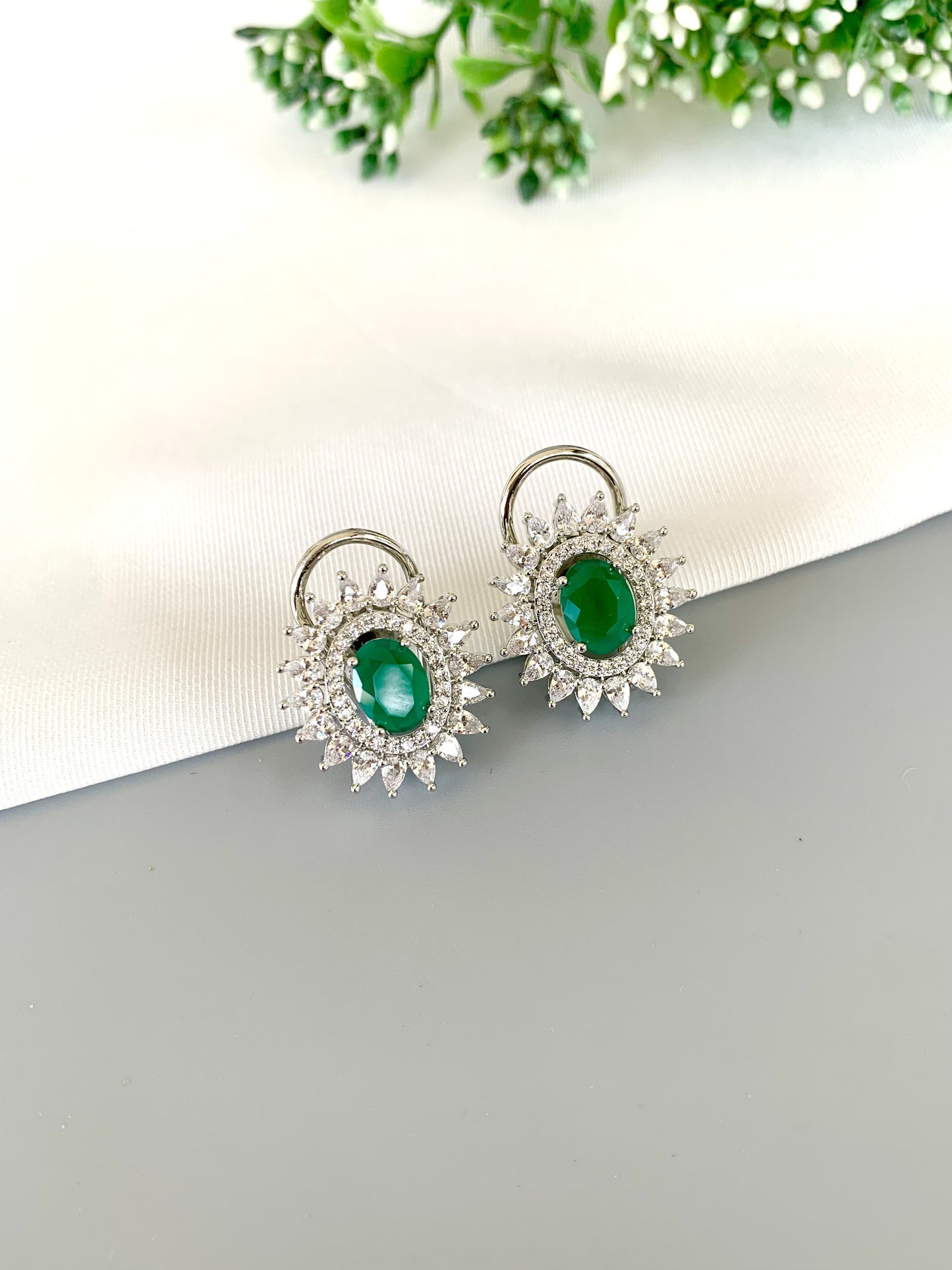 Front view of Hermona Emerald Studs in Rhodium plating with American Diamond halo