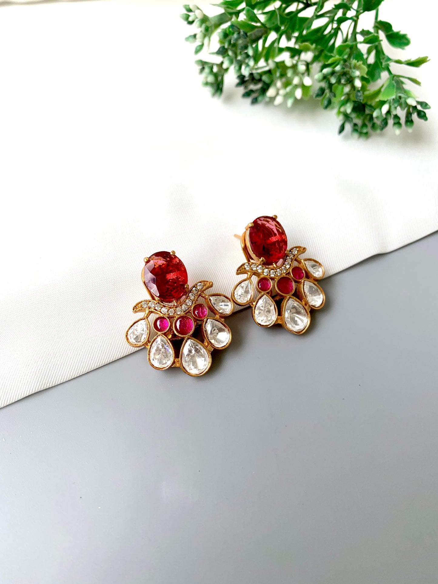Top-angle view of Kavia Ruby earrings highlighting gold floral design and Polki Kundan work.