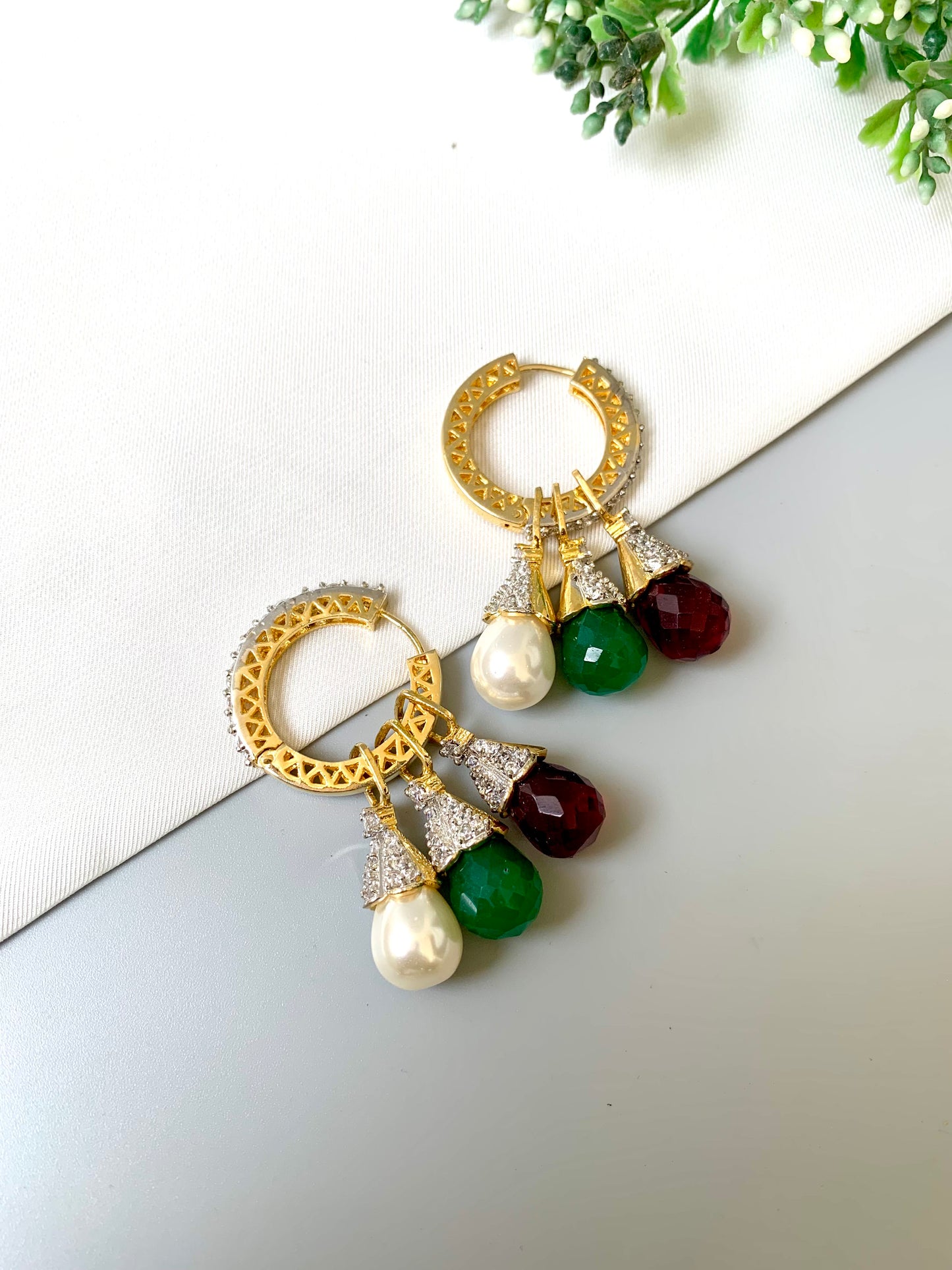 Close-up of multi-use Luna hoops with 22kt gold polish, customizable gemstone drops and American Diamond accents
