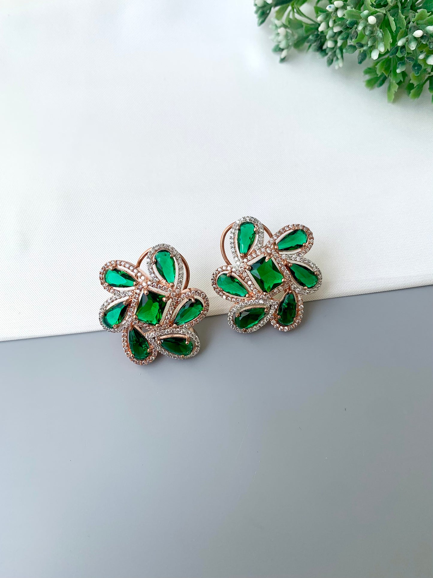 Naino rose gold plated studs with American diamonds and emerald accents