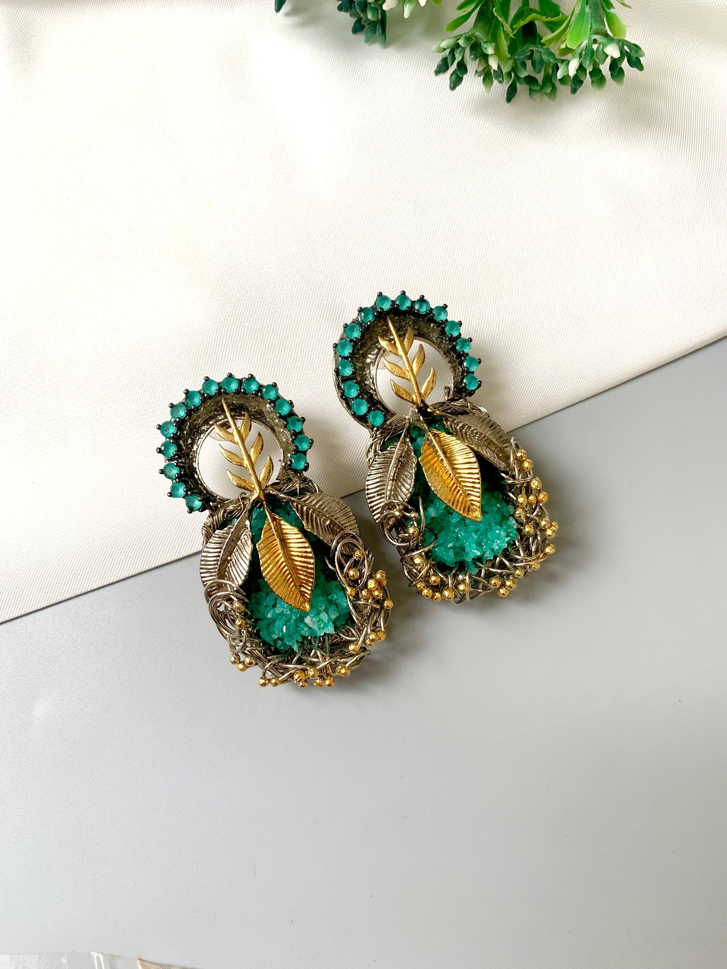 Rhodium plated handcrafted earrings with semi-precious green gemstones and metallic leaf accents from Zamal Jewels