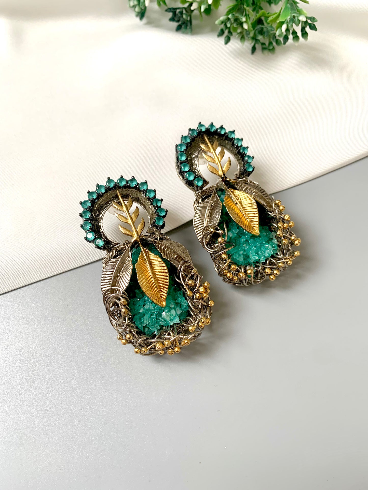 Rhodium plated handcrafted earrings with semi-precious green gemstones and metallic leaf accents from Zamal Jewels