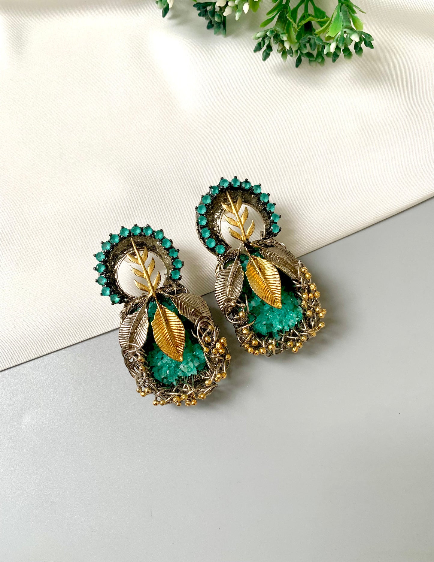 Rhodium plated handcrafted earrings with semi-precious green gemstones and metallic leaf accents from Zamal Jewels