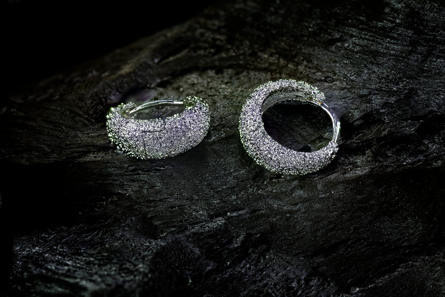 Handcrafted Venice Hoops with textured Rhodium plating in platinum finish displayed on a dark background