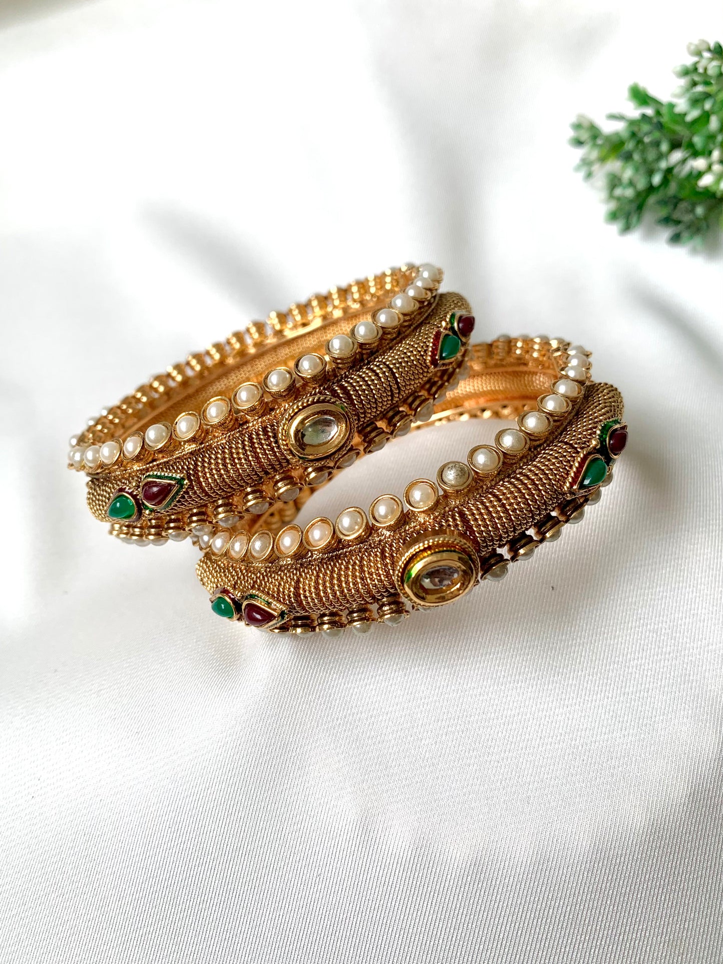 Pair of handcrafted 22kt gold plated openable screw bangles with Kundan, semi-precious pearls, ruby, and emerald stones