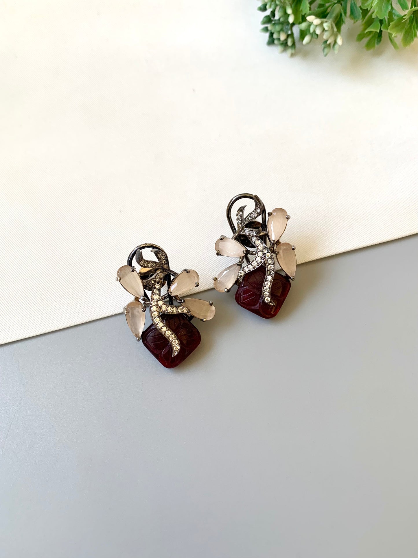 Pair of earrings with gemstones on a light surface