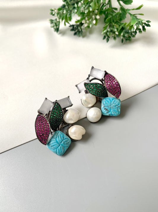 Rhodium oxidized black polish studs with semi-precious onyx, baroque pearls, ruby and emerald Swarovski crystals, and hand-carved turquoise feroza from Zamal Jewels