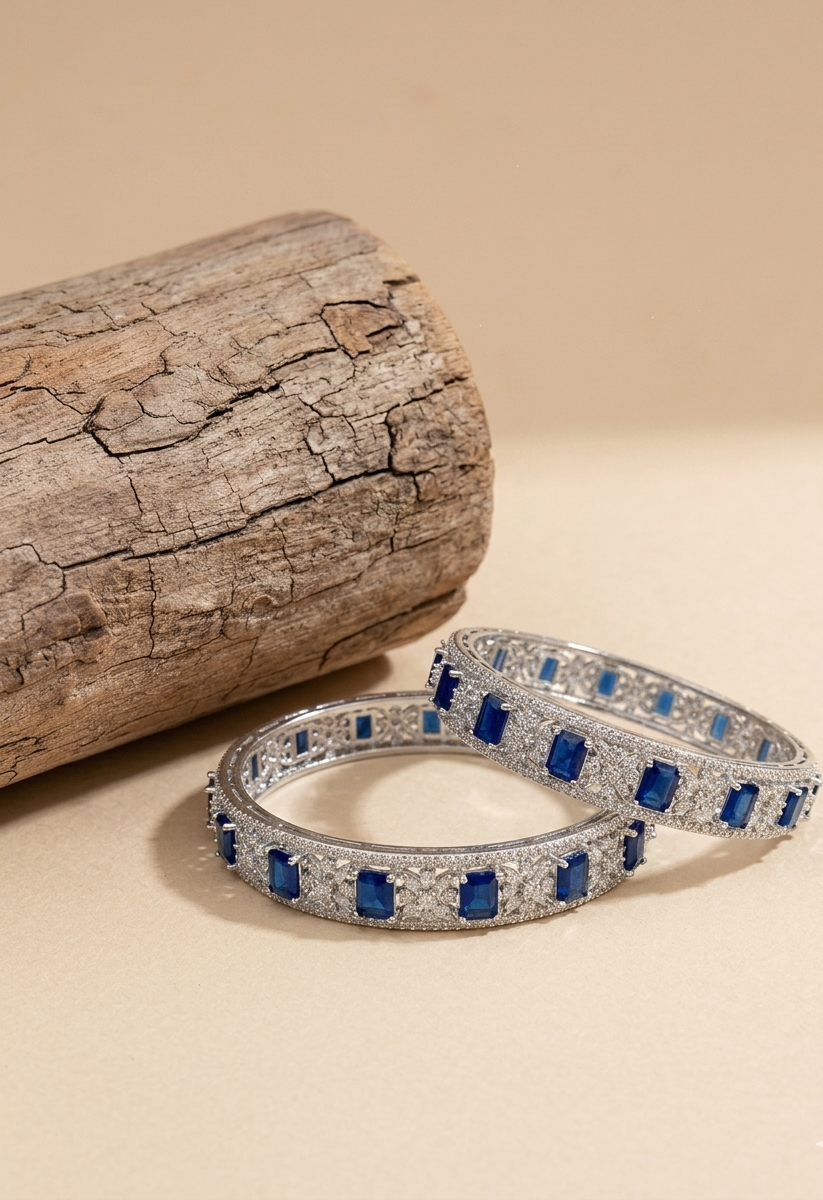 Bangles featuring a series of blue semi-precious sapphires set in a rhodium-plated, silver and bronze base.