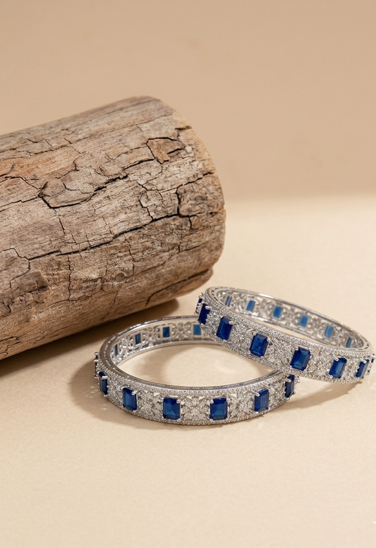 Bangles featuring a series of blue semi-precious sapphires set in a rhodium-plated, silver and bronze base.