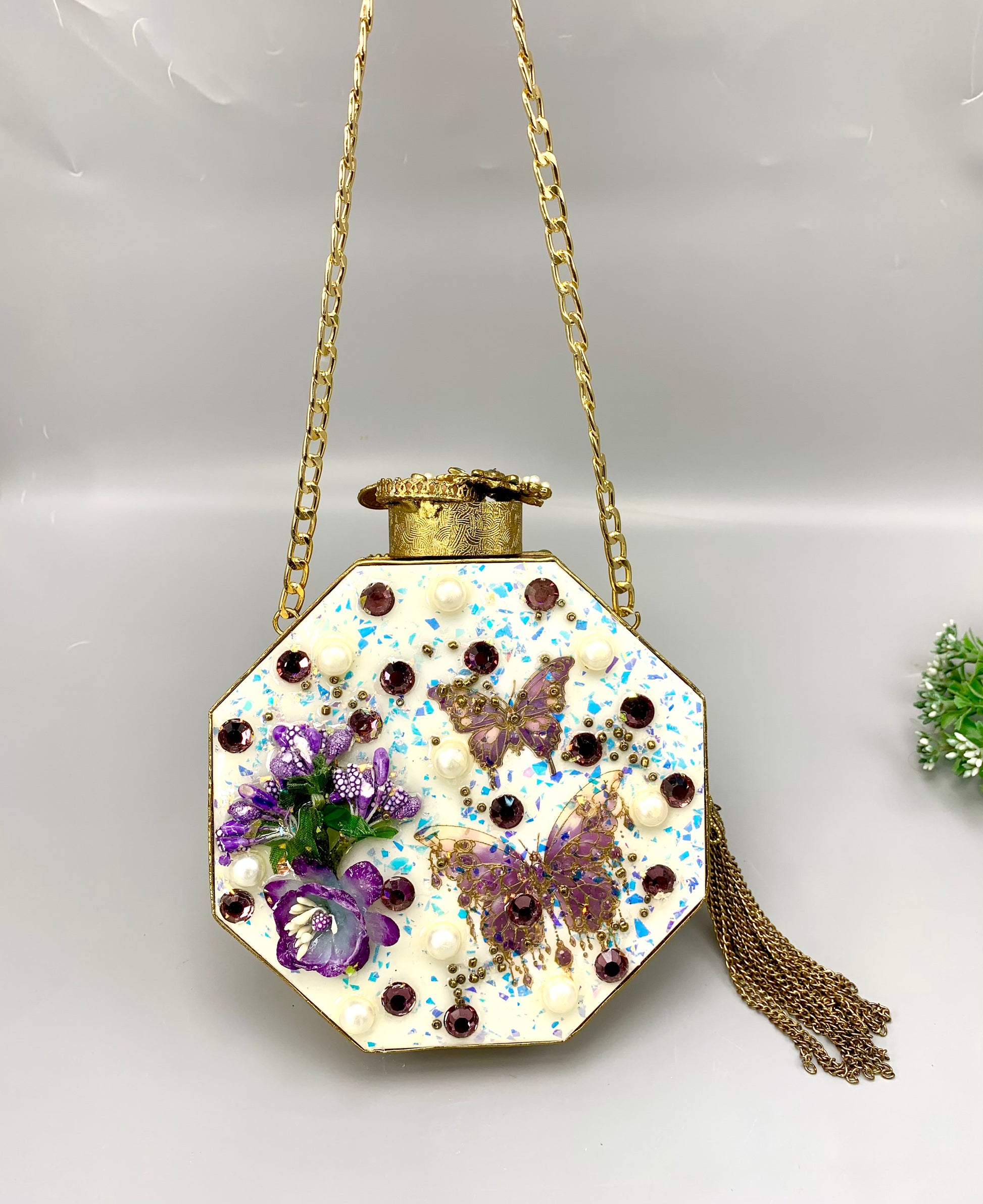 Decorative handbag with floral and butterfly design on a white background