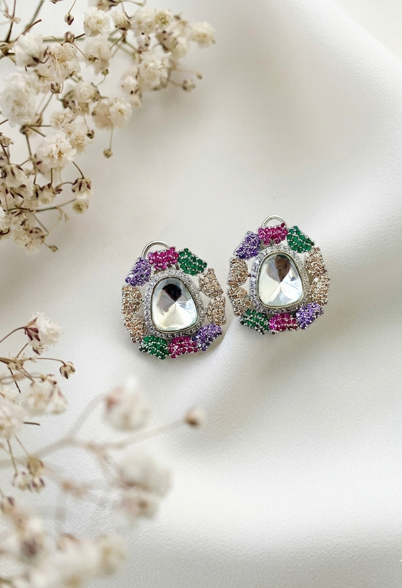Pair of ornate earrings with gemstones on a soft white background