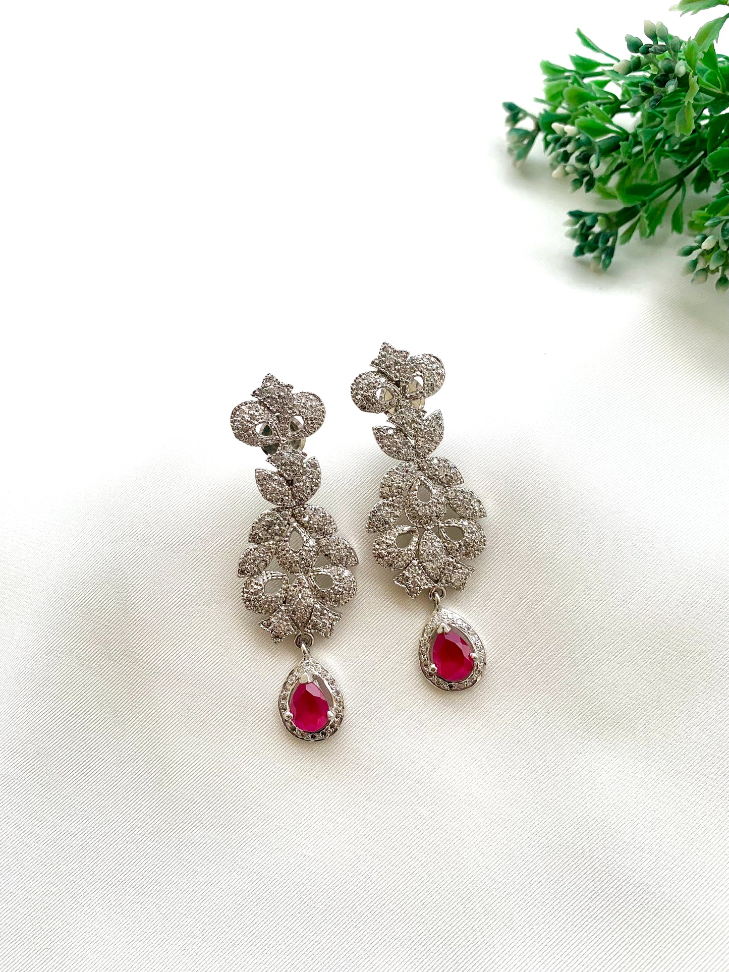 Gehna handcrafted rhodium plated earrings with a diamond finish featuring American Diamonds and semi-precious Ruby