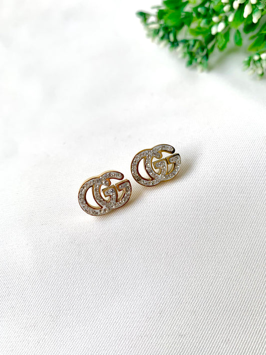 Gleia crystal gold studs with double-G design, 22K gold plated on 316L stainless steel by Zamal Jewels.