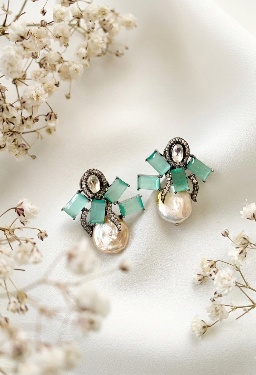 Earrings with turquoise and pearl design on a white background with small flowers.