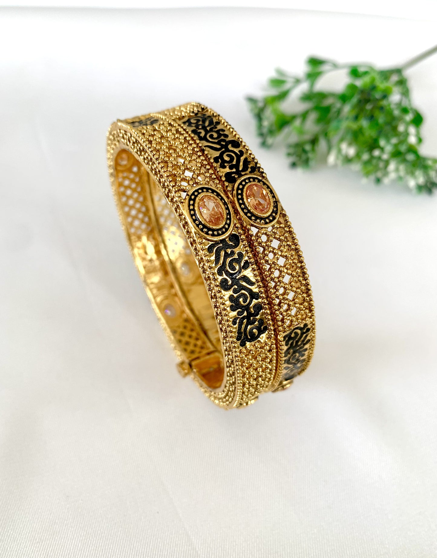 Traditional screw bangles with detailed gold texture and black enamel work