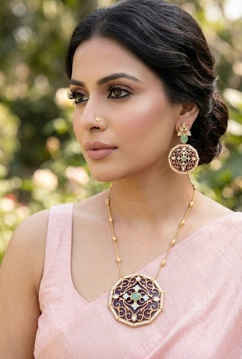 Woman wearing gold jewelry with a pink background