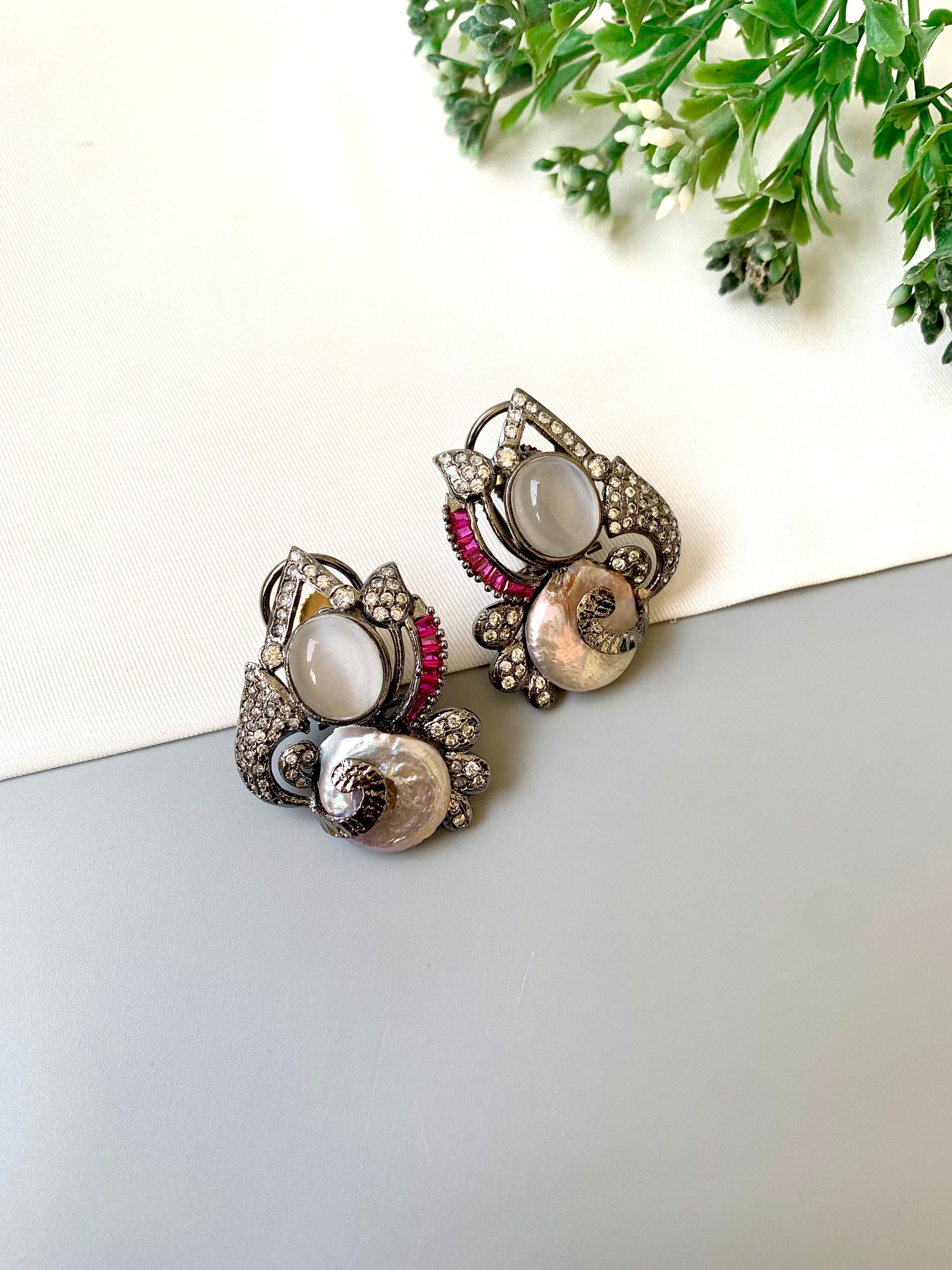 Handcrafted oxidized rhodium studs with real baroque pearls, rubies, and American diamonds by Zamal Jewels.