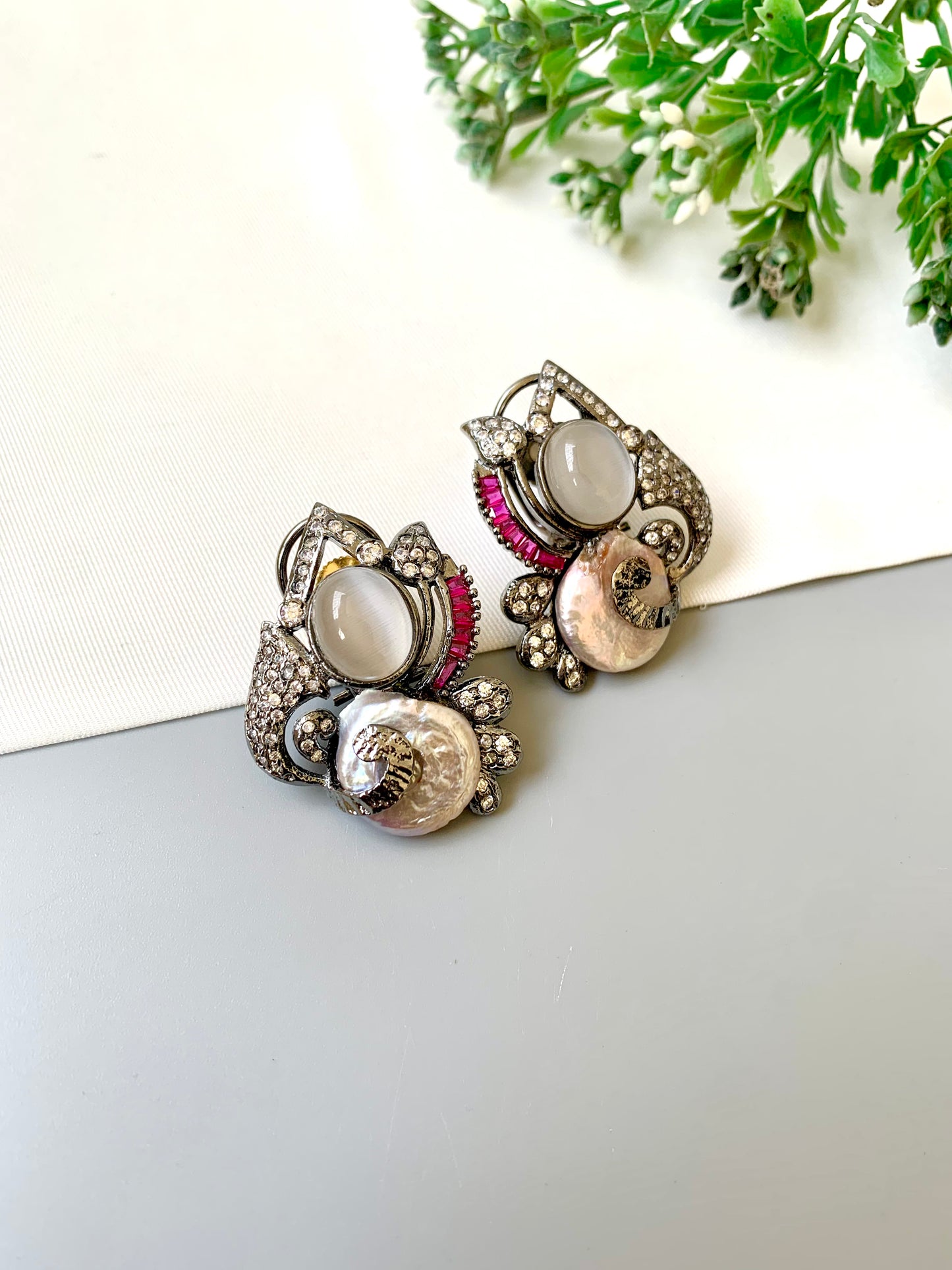 Handcrafted oxidized rhodium studs with real baroque pearls, rubies, and American diamonds by Zamal Jewels.
