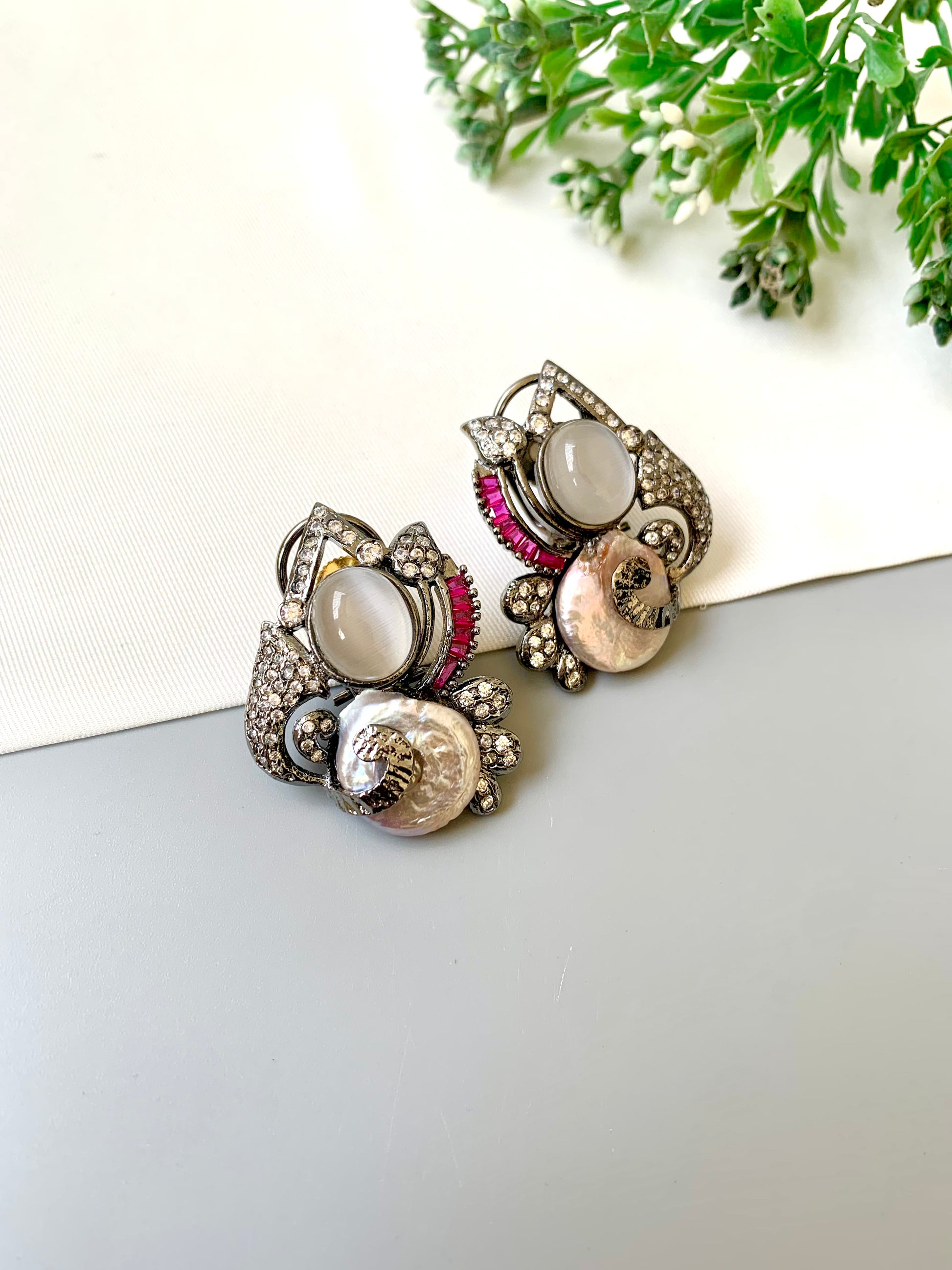 Handcrafted oxidized rhodium studs with real baroque pearls, rubies, and American diamonds by Zamal Jewels.