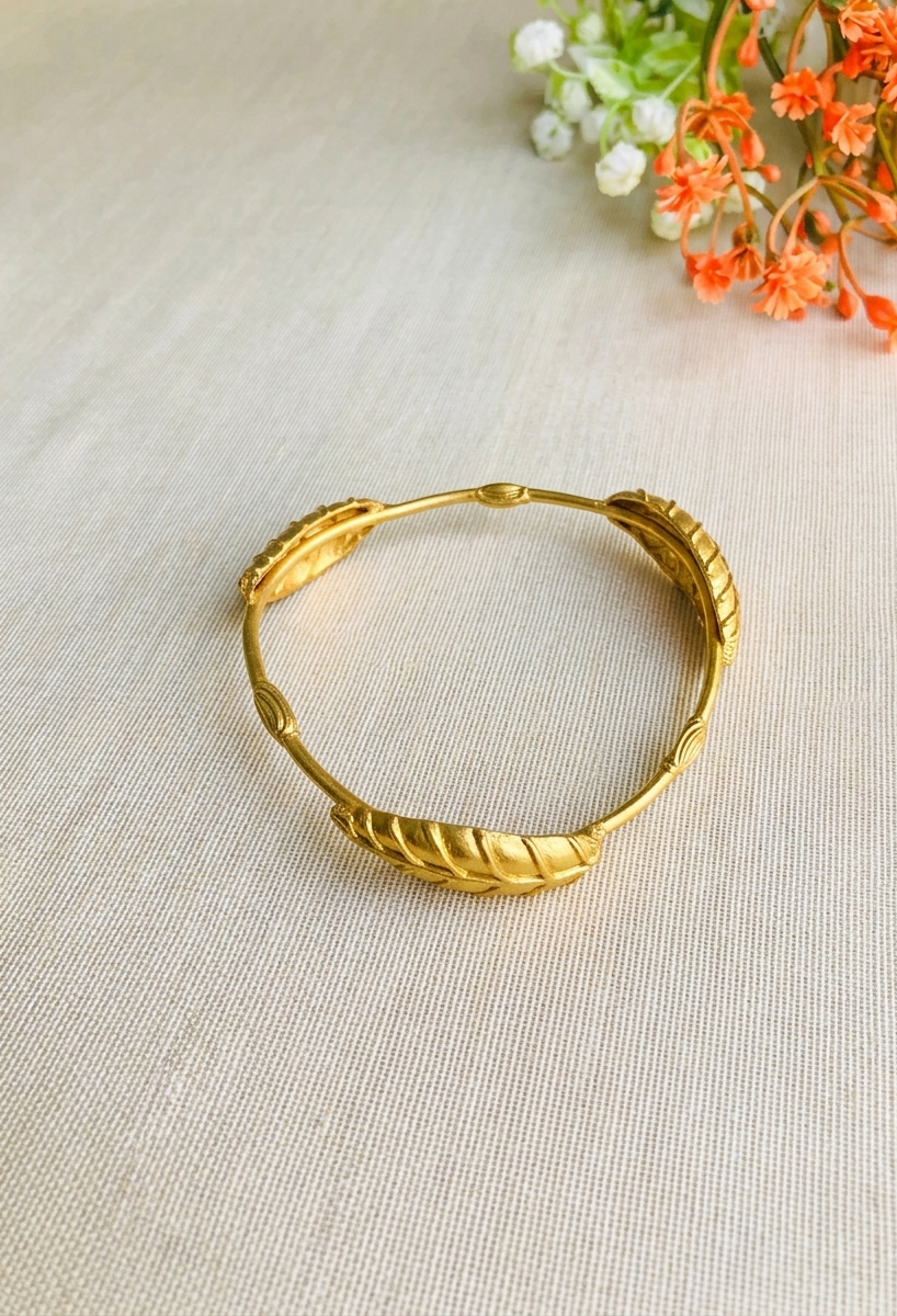Rishani geometric gold bangle in curved triangular shape with hand carved leaf design