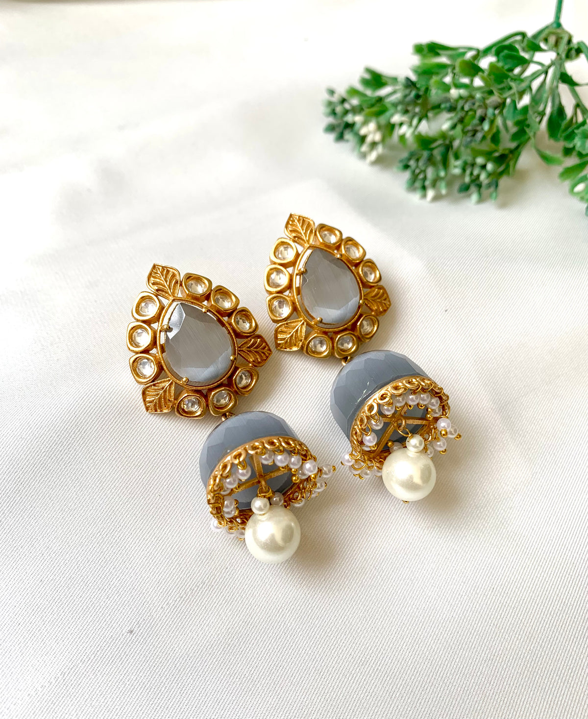 A pair of earrings featuring high quality Polki Kundan, semi-precious Onyx, and pearls with a 22kt gold plated base.