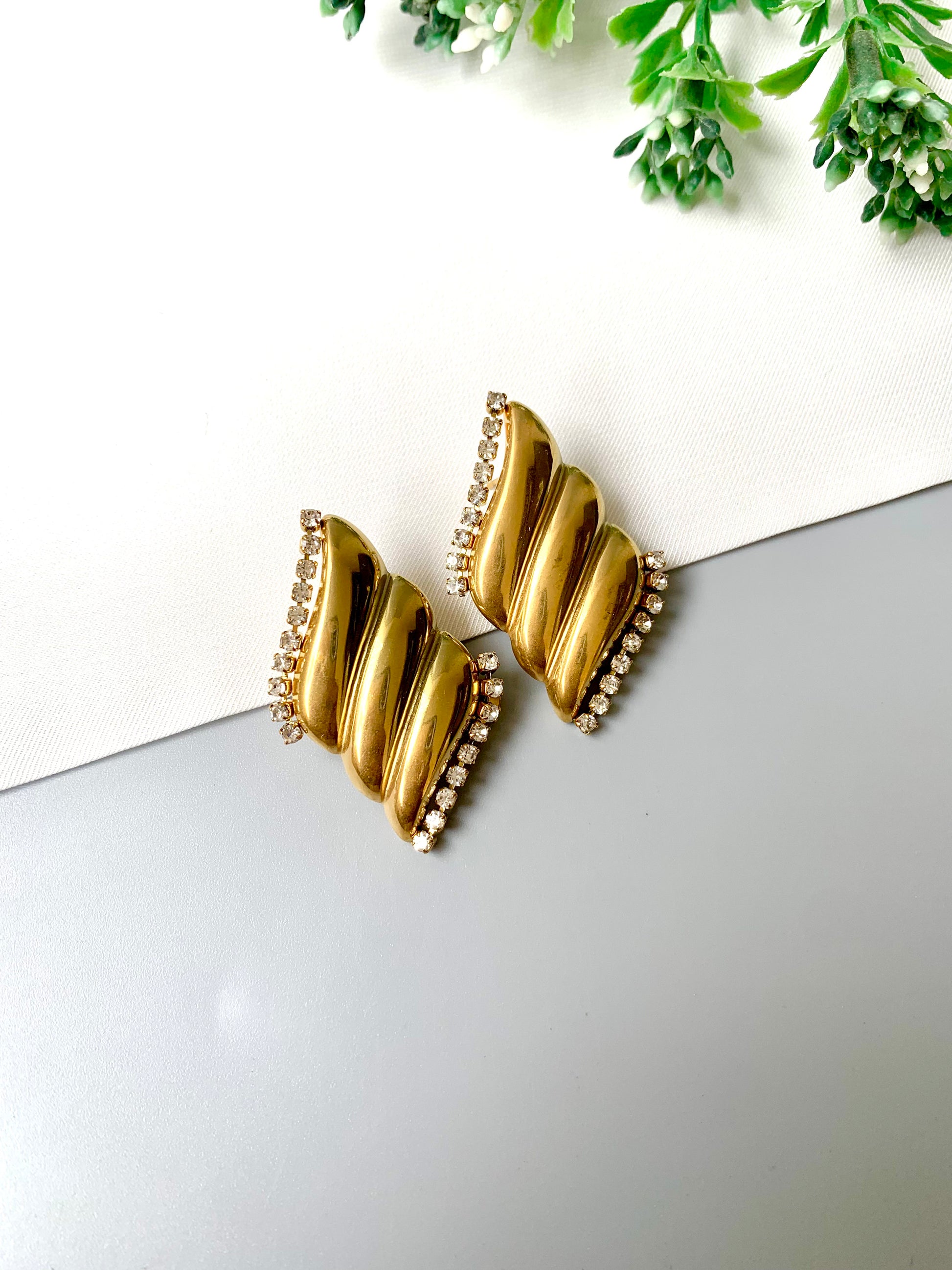 Gold-plated stainless steel studs with zircon border accents, named Solna, displayed flat lay on neutral background