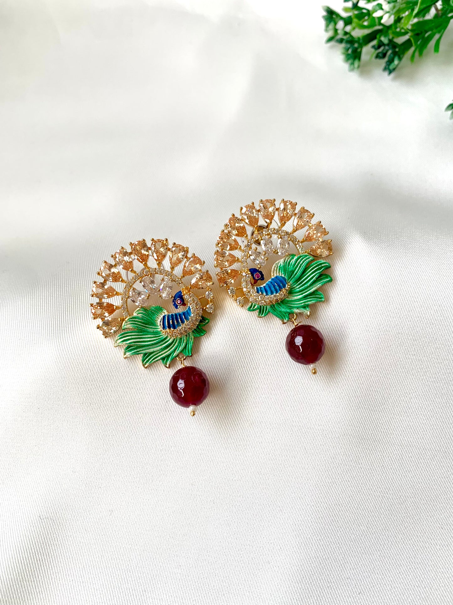 Hand crafted Vire Champagne peacock designer earrings in 22kt gold plating with American Diamonds, semi-precious champagne & ruby and hand-painted Meena
