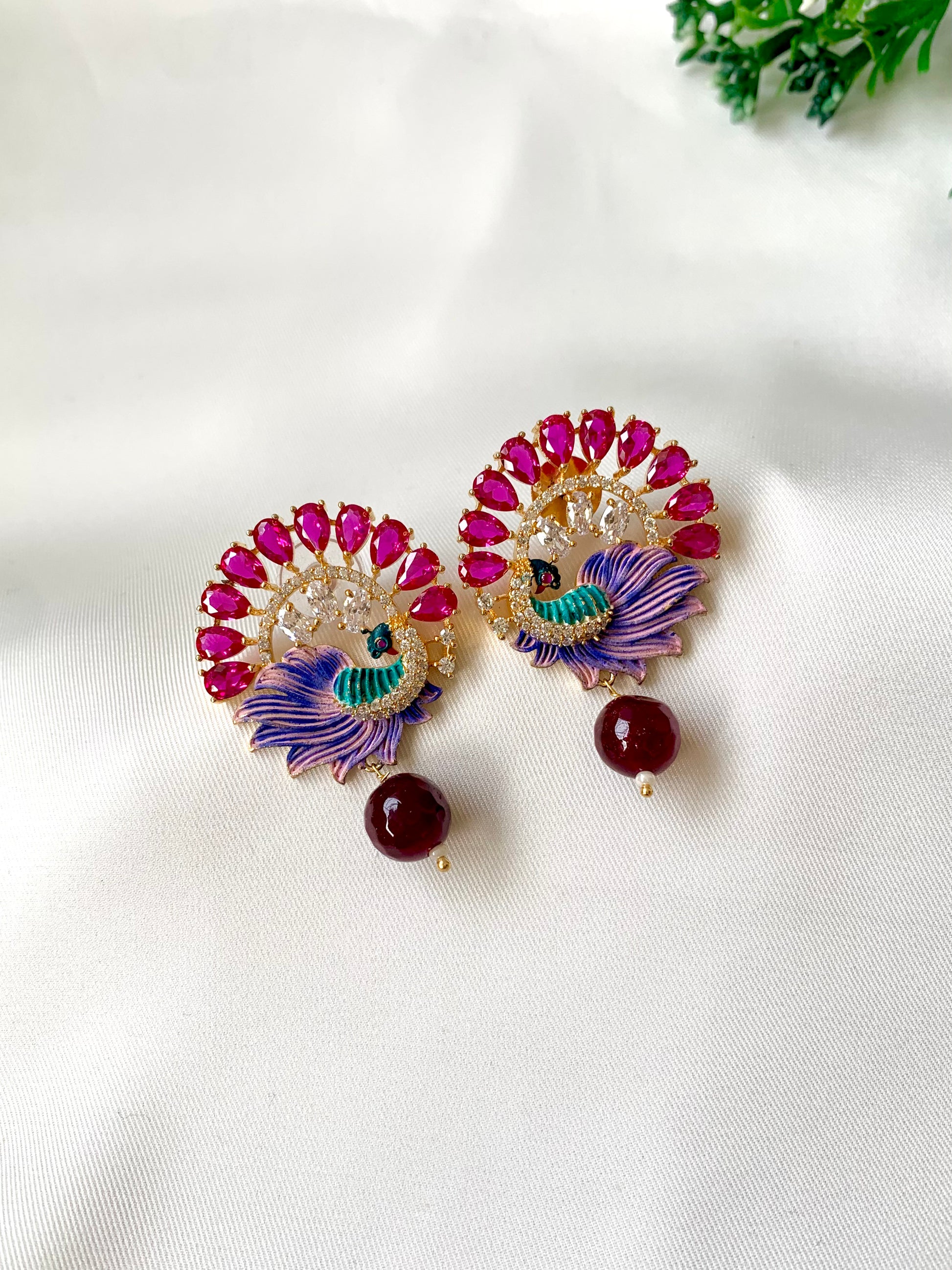 Hand crafted Vire Ruby peacock designer earrings in 22kt gold plating with American Diamonds, semi-precious ruby and hand-painted Meena