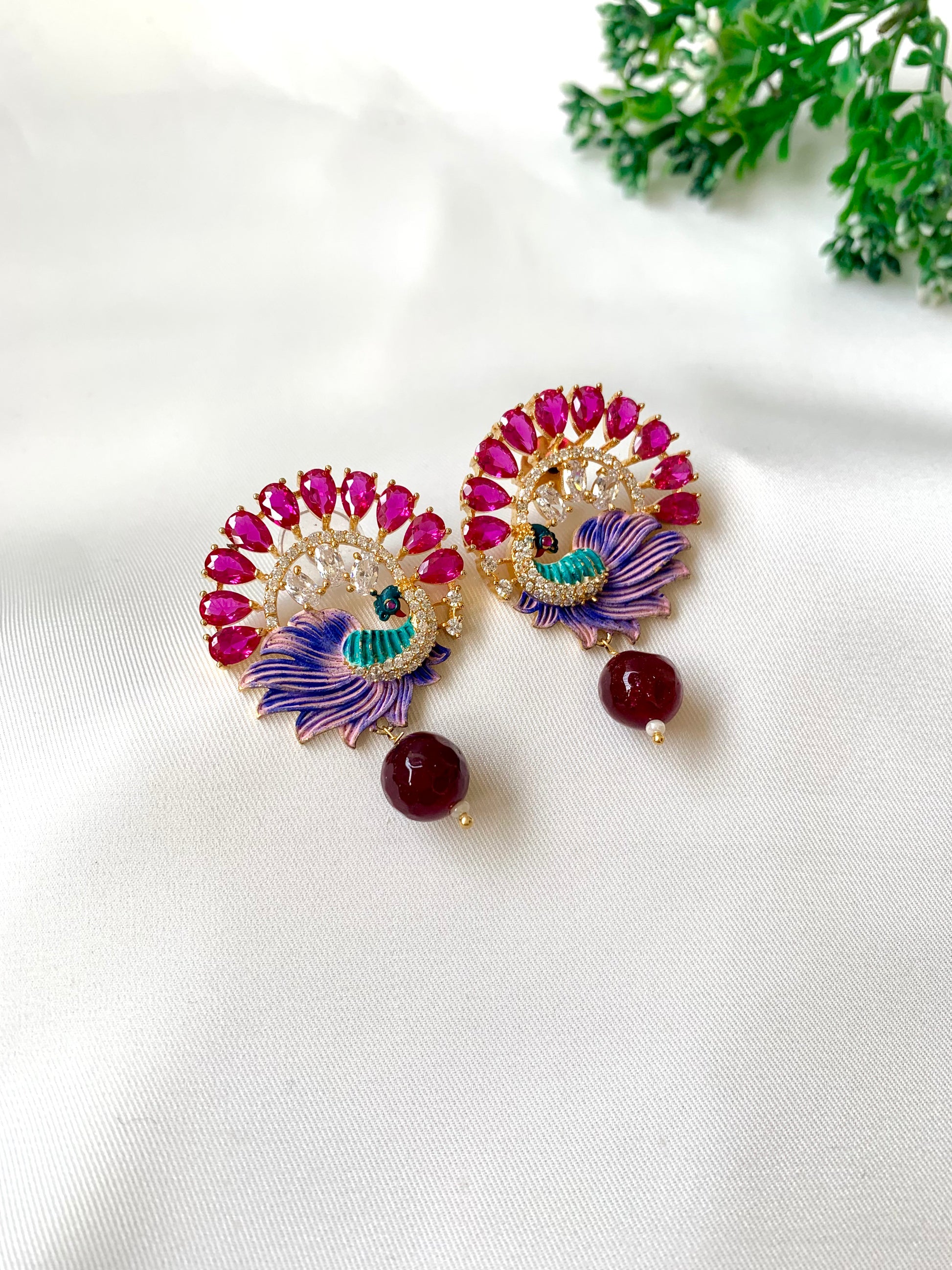 Hand crafted Vire Ruby peacock designer earrings in 22kt gold plating with American Diamonds, semi-precious ruby and hand-painted Meena
