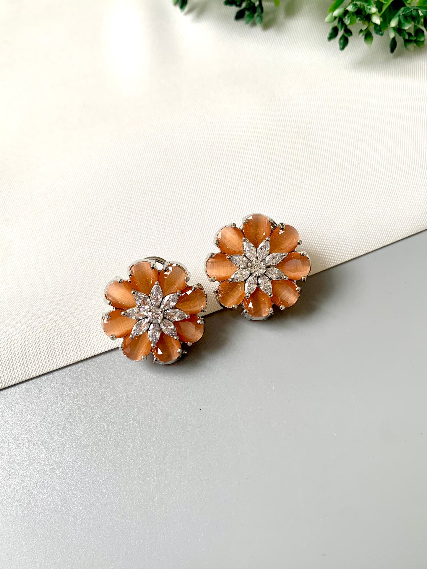 Rhodium plated floral stud earrings featuring semi-precious amber onyx petals and high-quality American Diamonds from Zamal Jewels