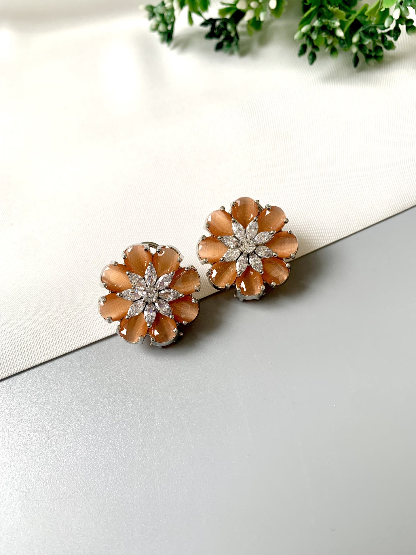 Rhodium plated floral stud earrings featuring semi-precious amber onyx petals and high-quality American Diamonds from Zamal Jewels