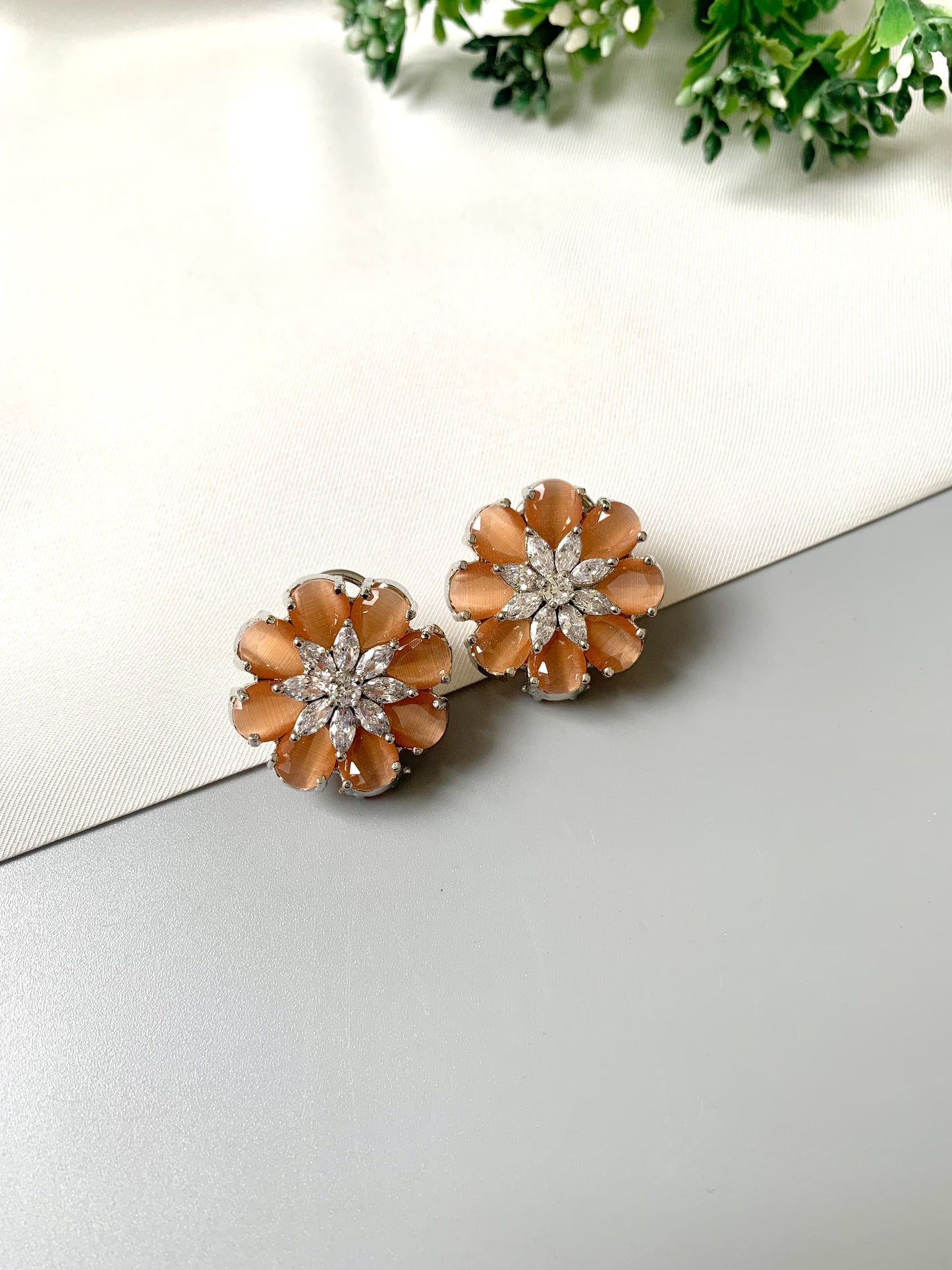Rhodium plated floral stud earrings featuring semi-precious amber onyx petals and high-quality American Diamonds from Zamal Jewels