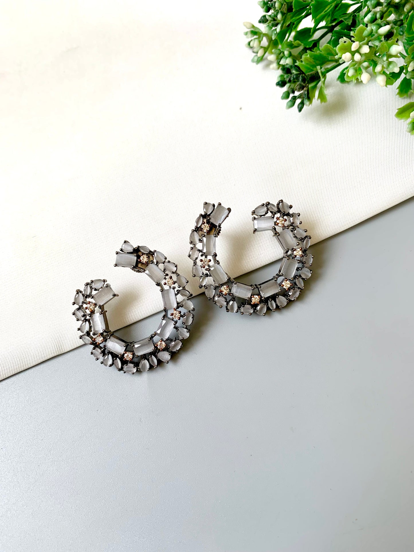 Modern oxidized hoops featuring baguette and teardrop stones in a full-circle silhouette with a monochrome look