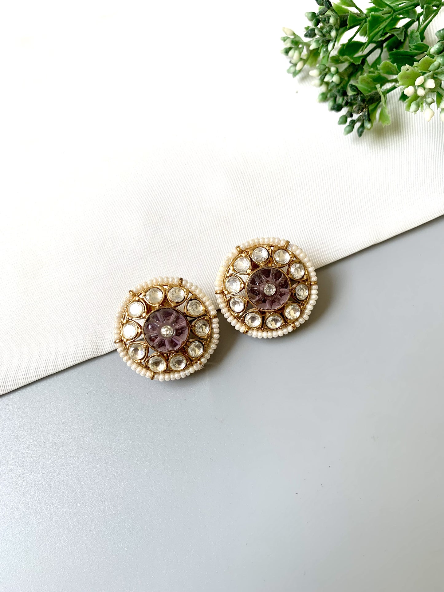 Ariya Studs with Polki Kundan stones, pearl border, and floral hand-carved amethyst center on grey background