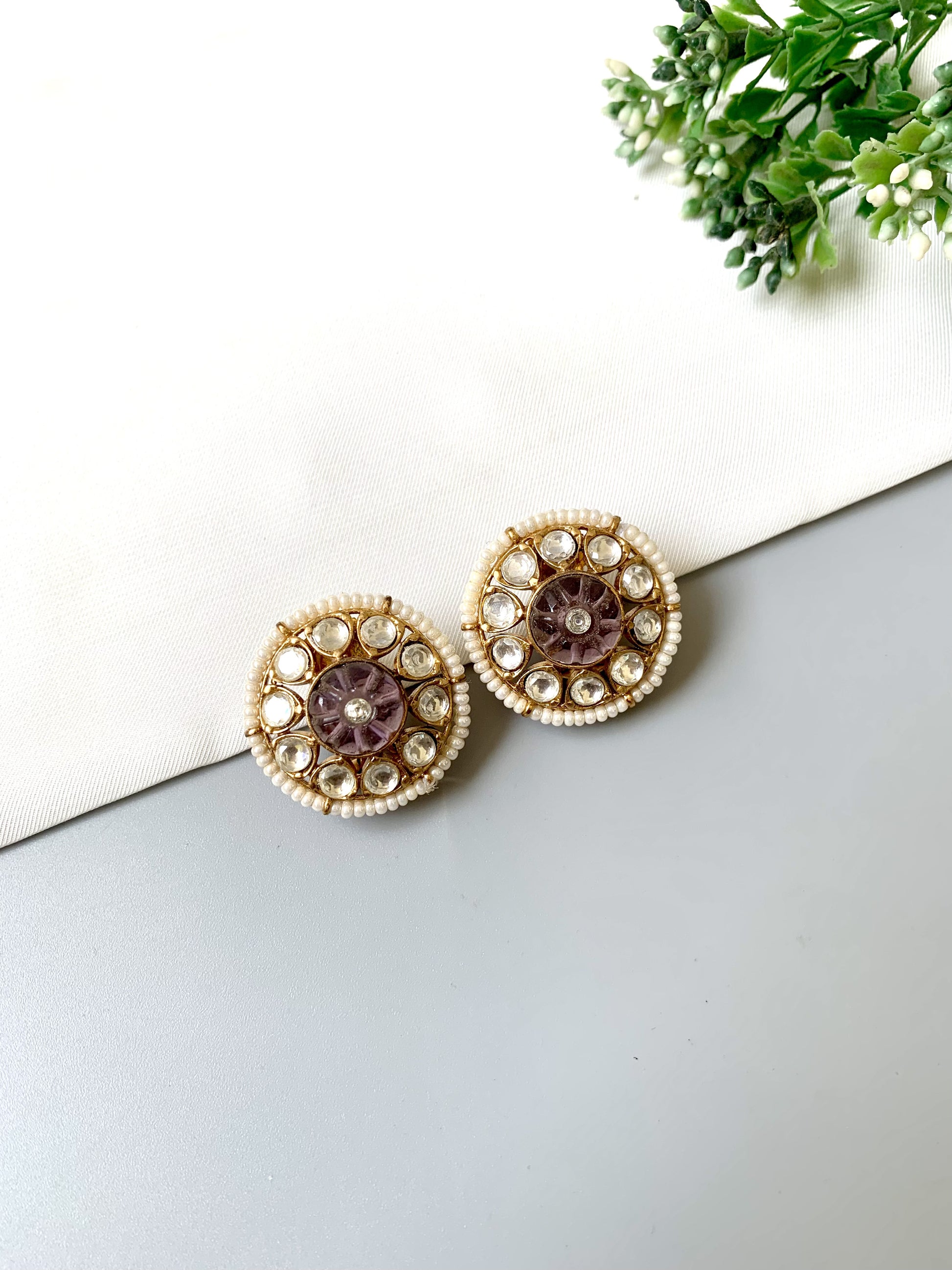 Ariya Studs with Polki Kundan stones, pearl border, and floral hand-carved amethyst center on grey background