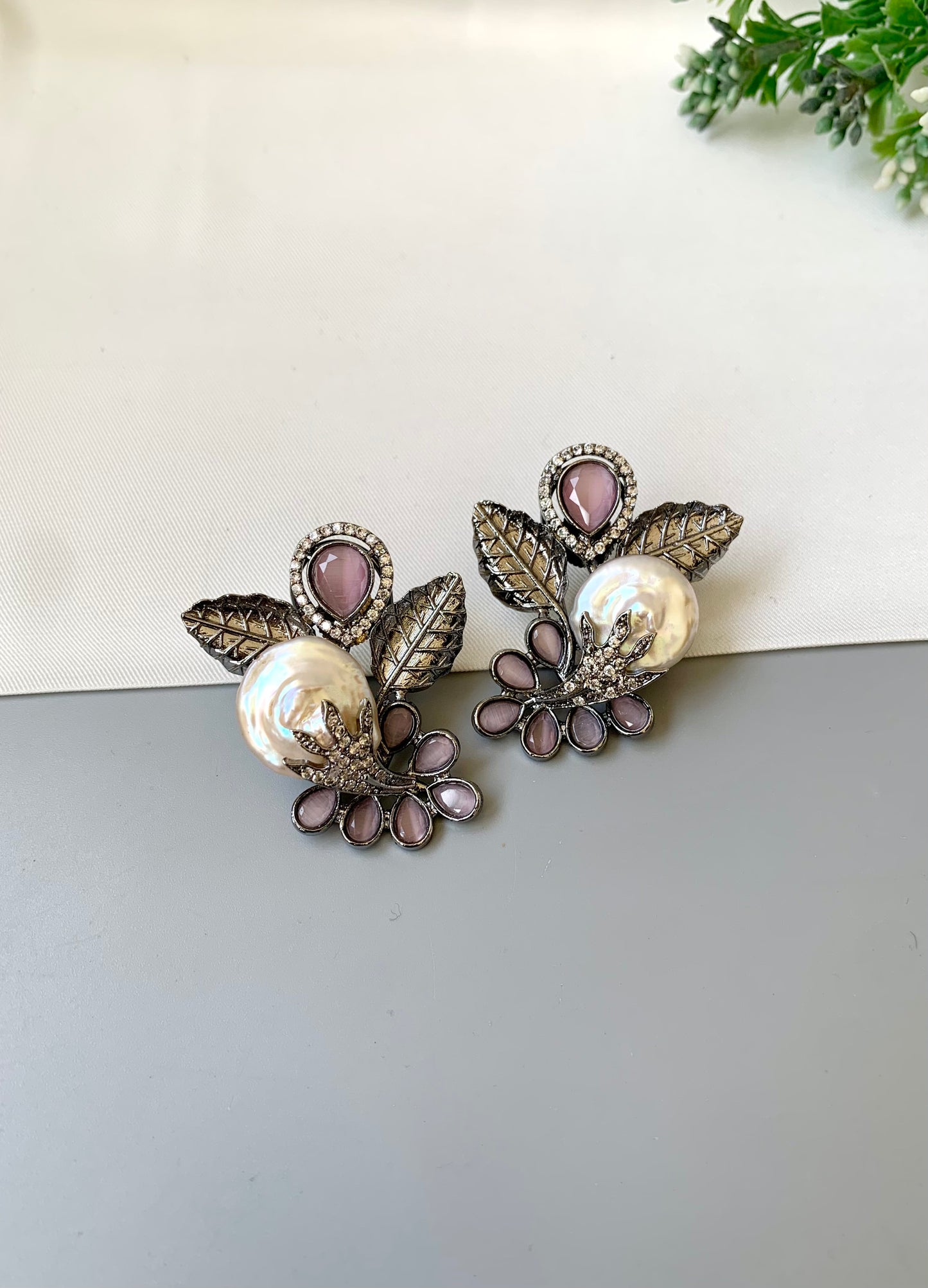 Dennis pink baroque pearl studs in rhodium oxidized finish with onyx and american diamonds
