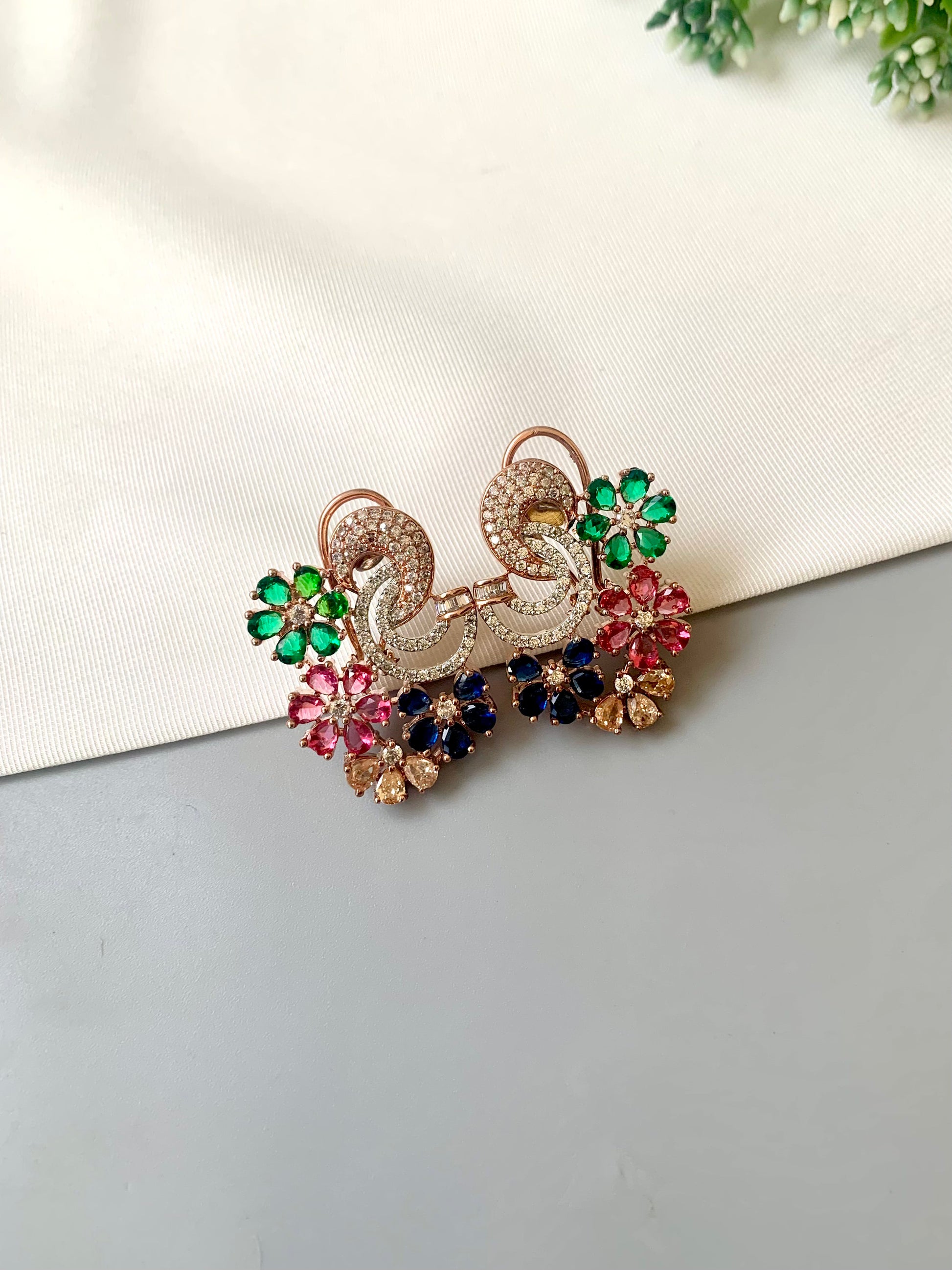 Hand crafted Dora studs in 22kt rose gold plating featuring American Diamonds and semi-precious Ruby, Emerald, Sapphire and Champagne stones